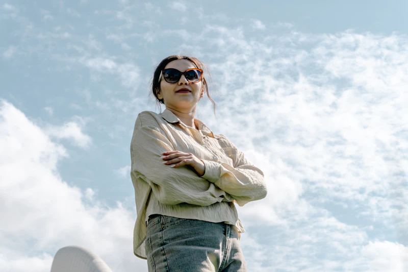 stylish older woman in sunglasses under a blue sky
