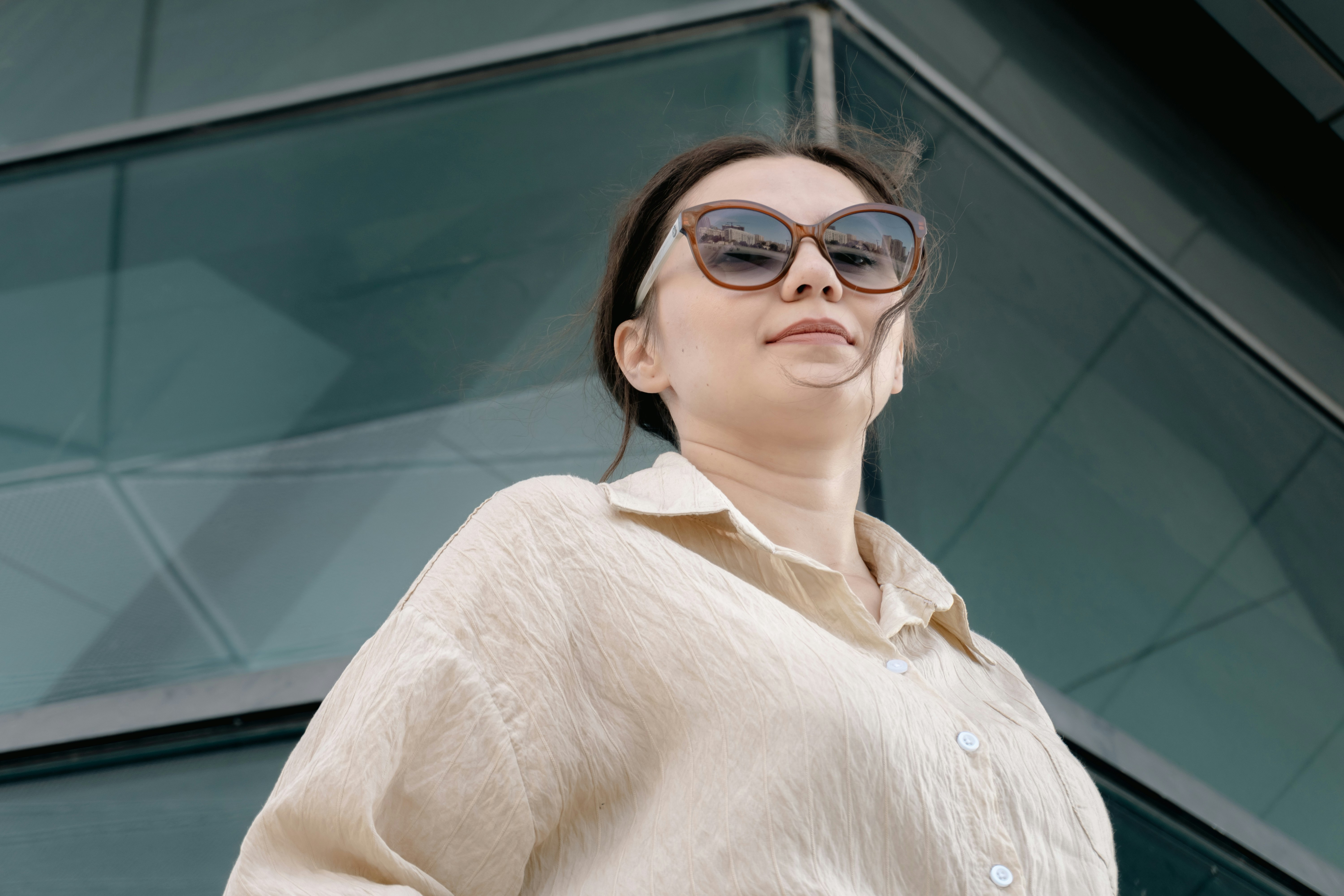 Stylish woman in sunglasses looking down from above.