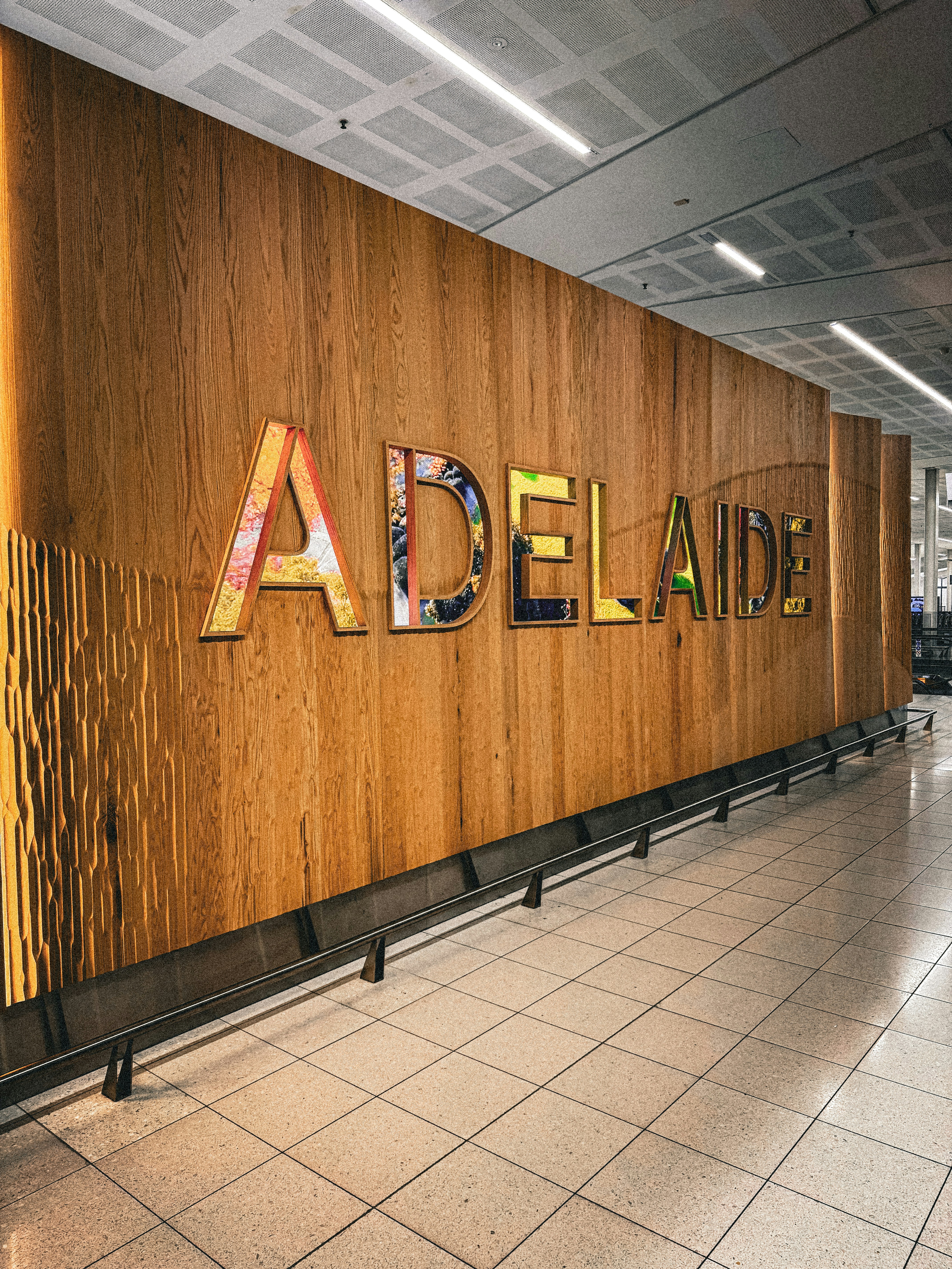Colorato cartello di Adelaide su un muro di legno testurizzato.