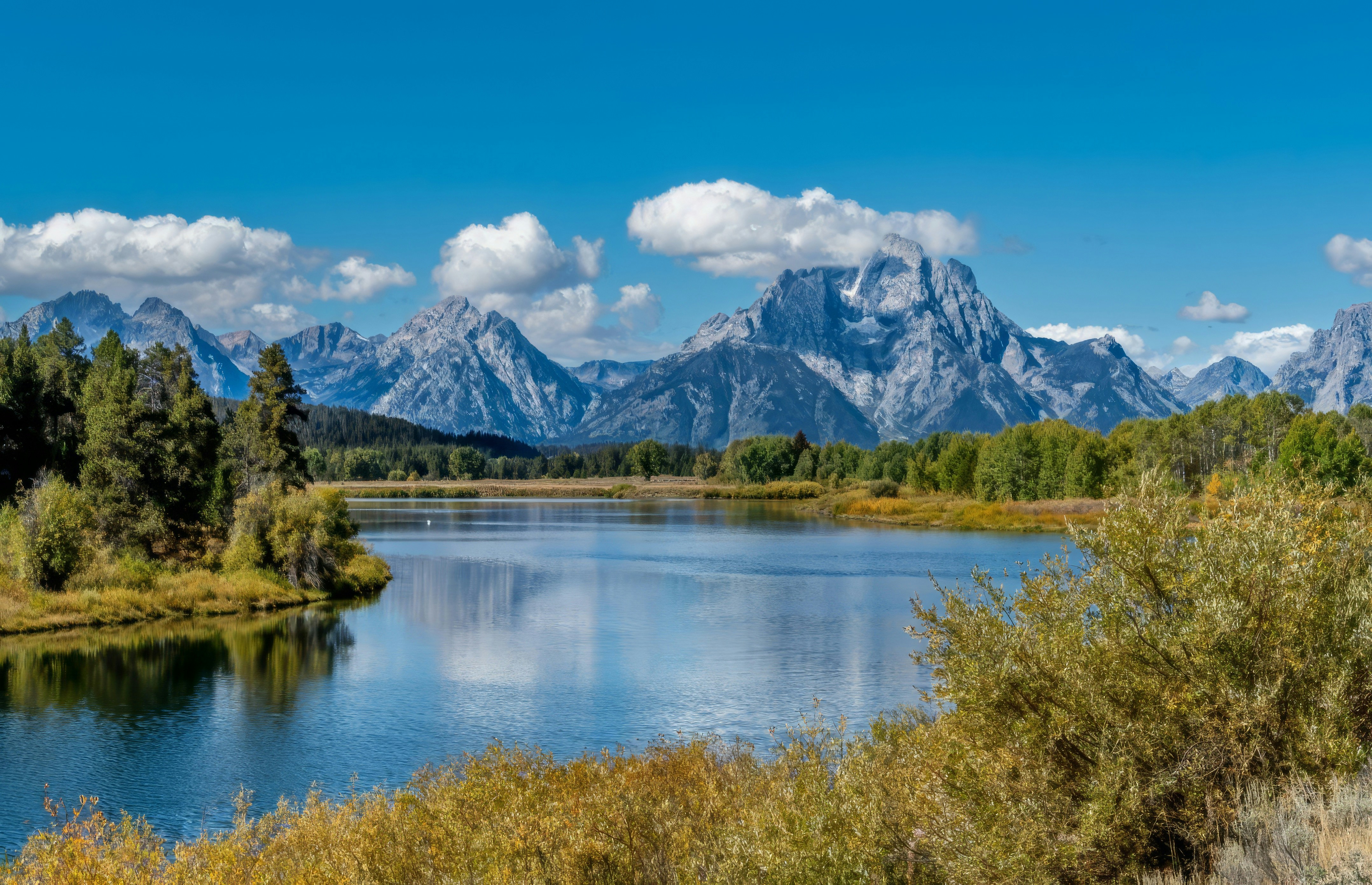 Beautiful mountain landscape with a reflective lake and blue sky.