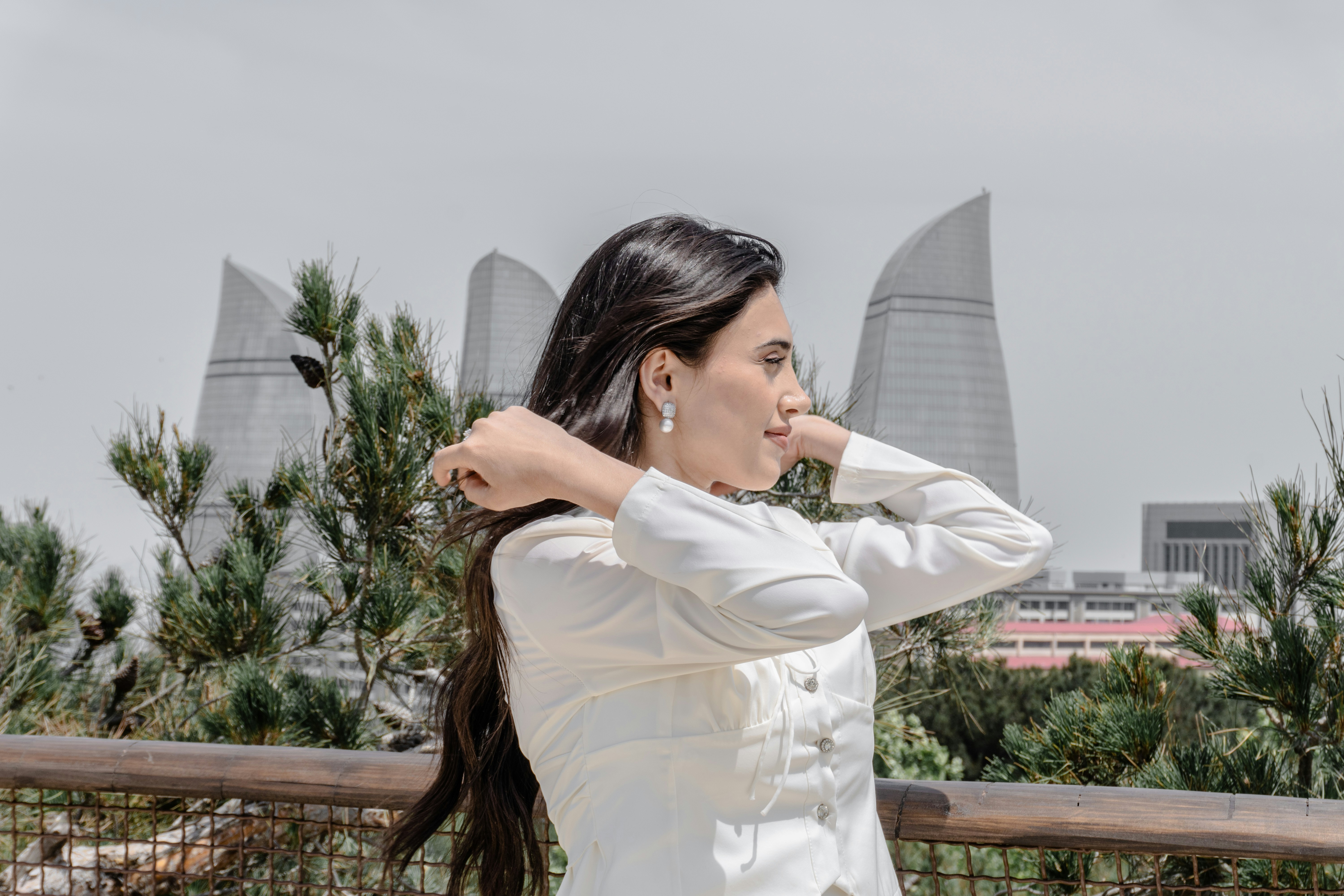 person wearing white wireless earbuds outdoors in urban environment