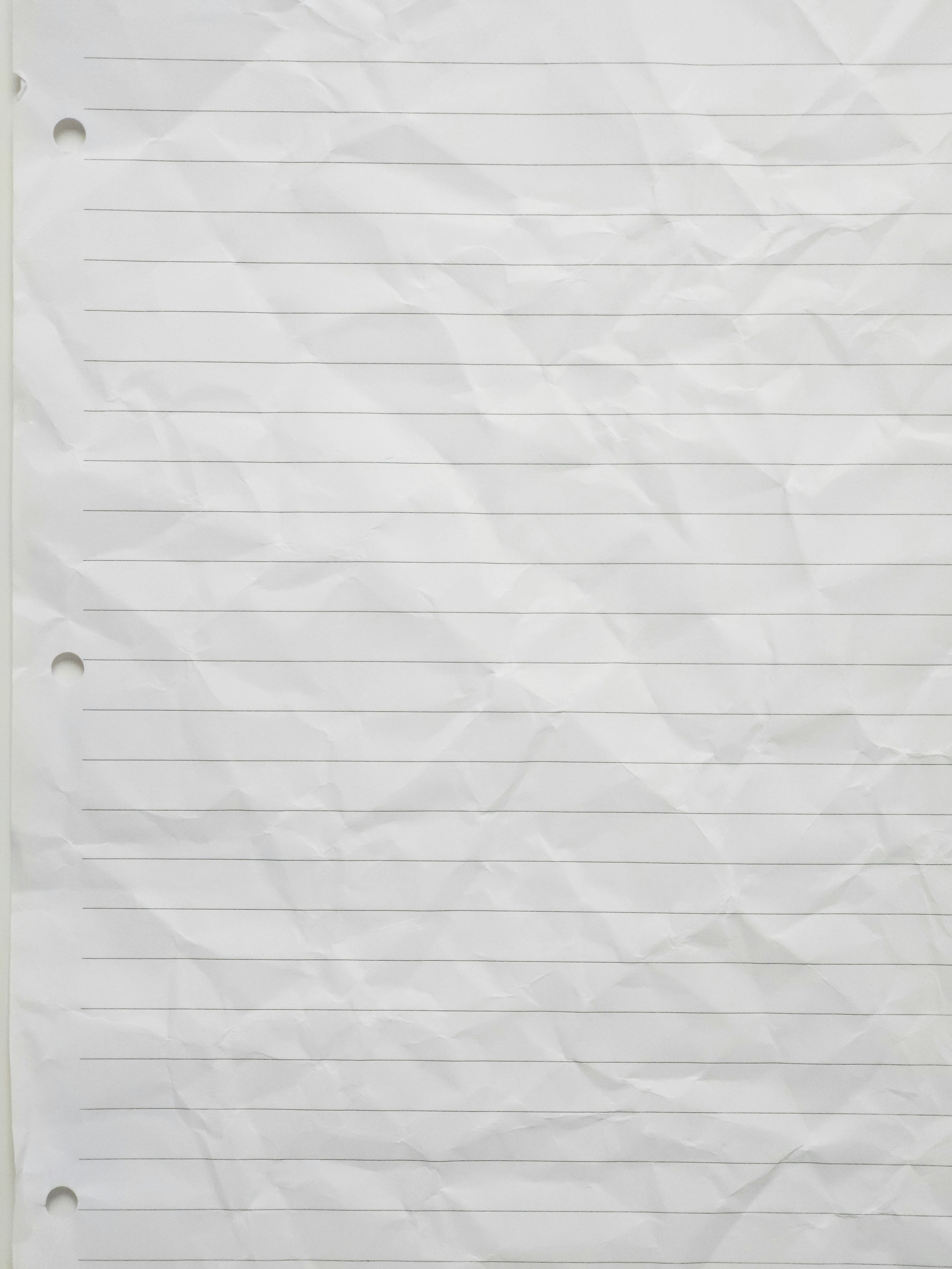 Crumpled, lined white paper with three holes