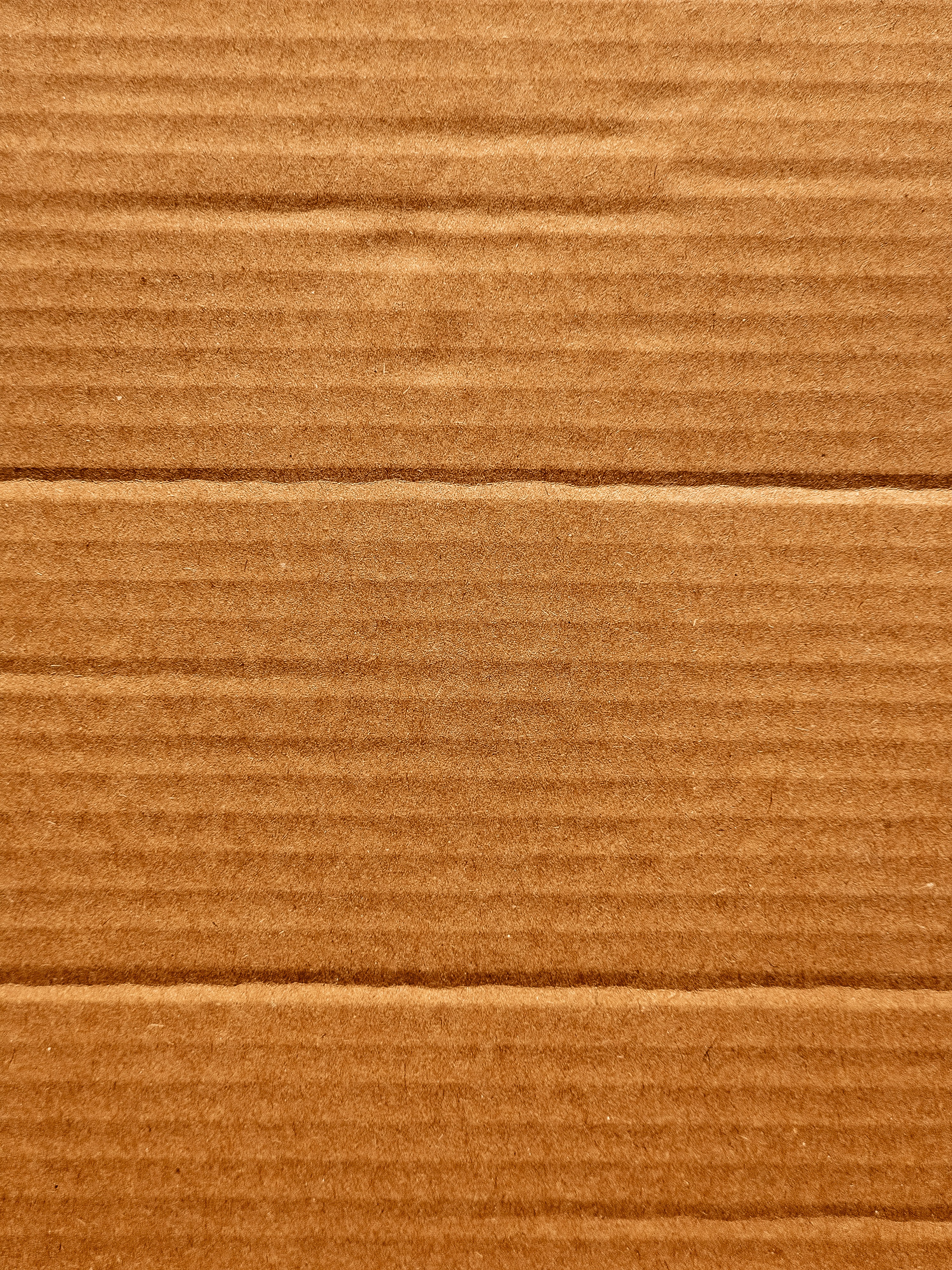 Fundo com textura de papelão corrugado marrom.