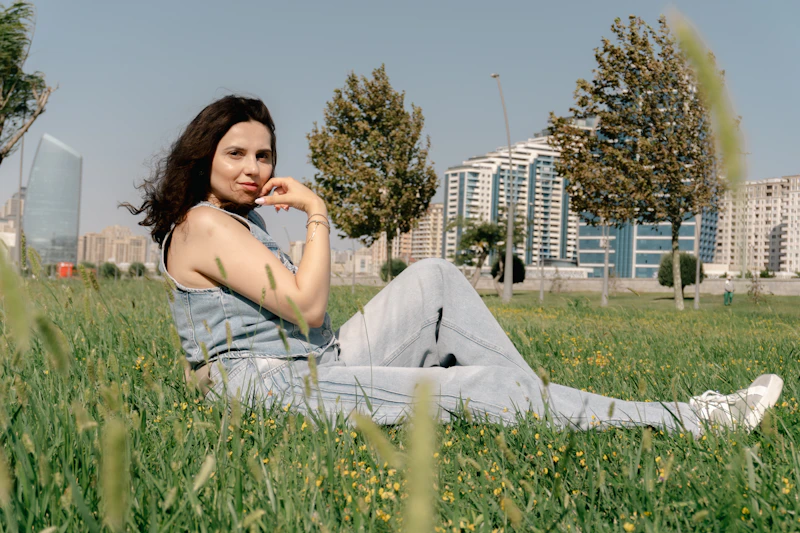 smiling woman relaxing on grass in a sunny park