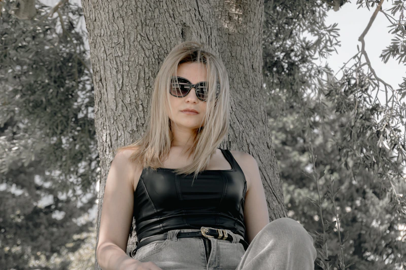 young sugar baby in sunglasses by a tree