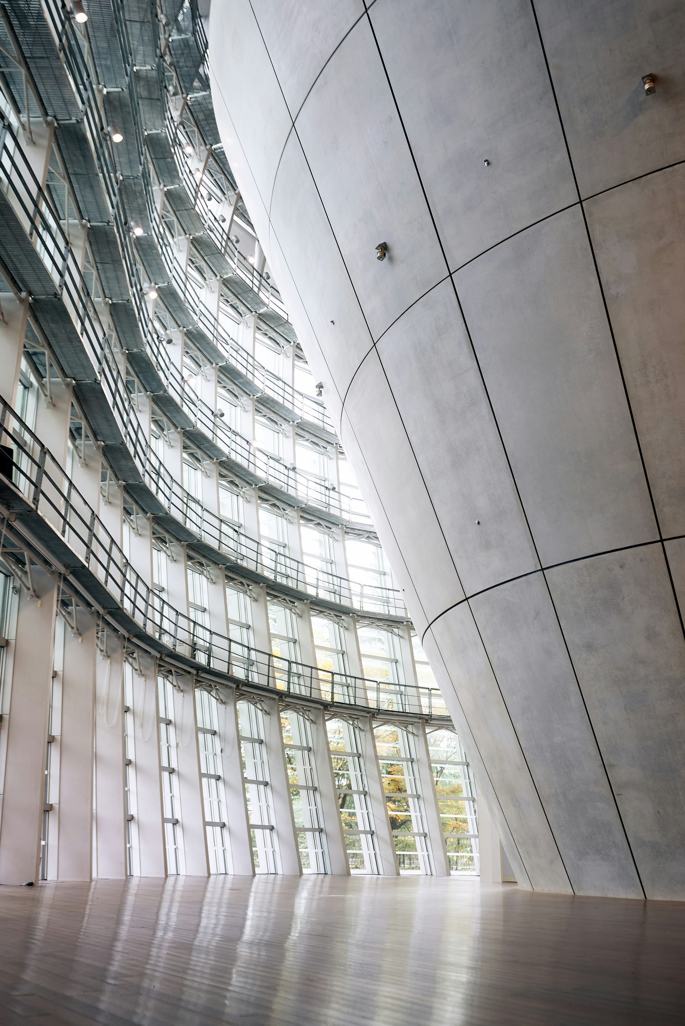 Curved concrete wall and glass windows in a modern interior.