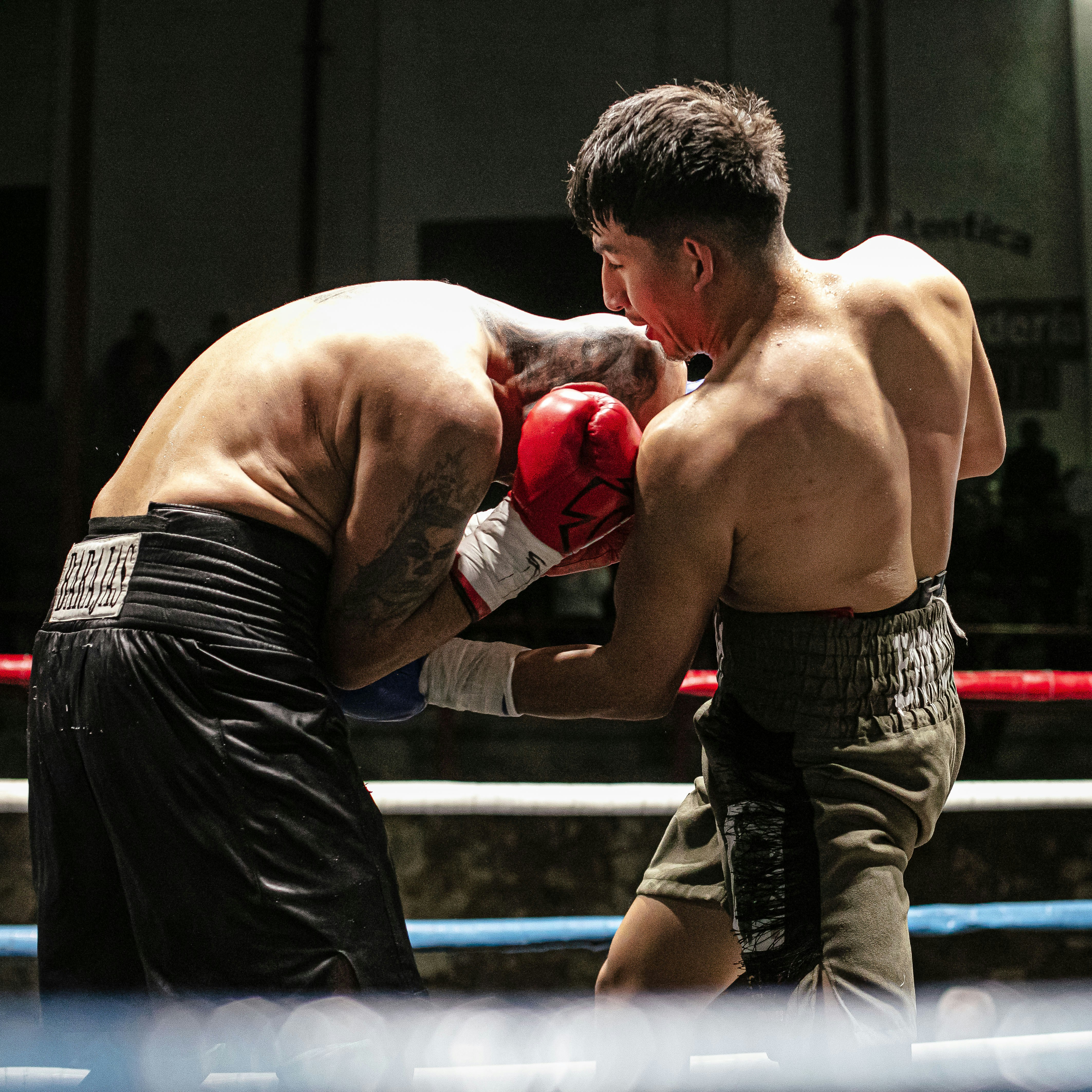 Two male boxers competing in a boxing match.