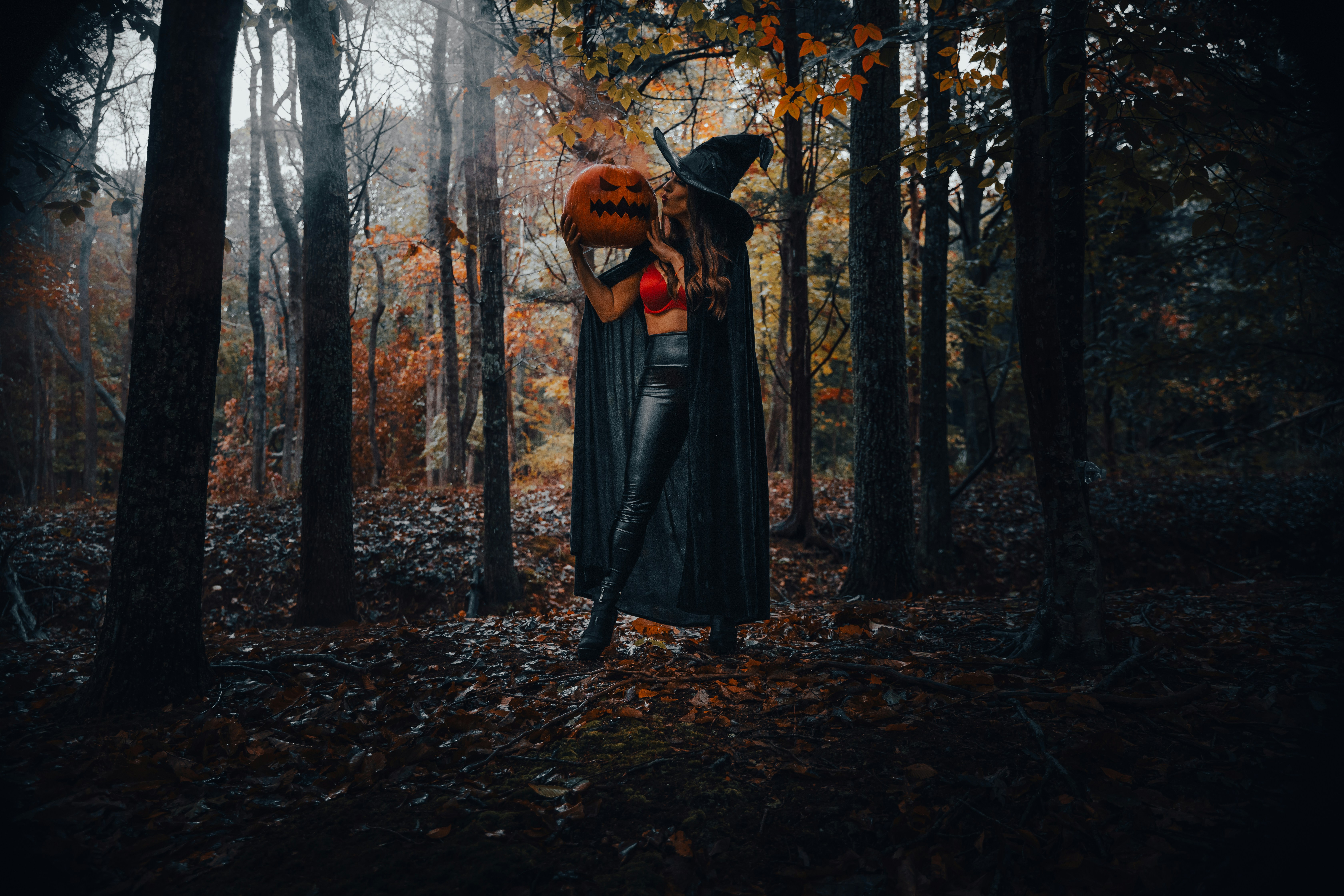 Dark A Witch Holding A Carved Pumpkin In A Dark Forest. 4K Wallpaper #3617