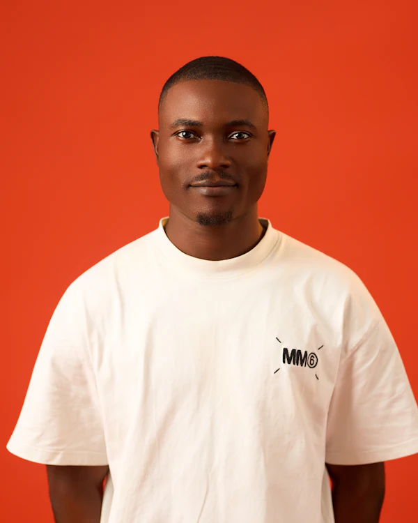 Man in a plain white T-shirt against an orange backdrop