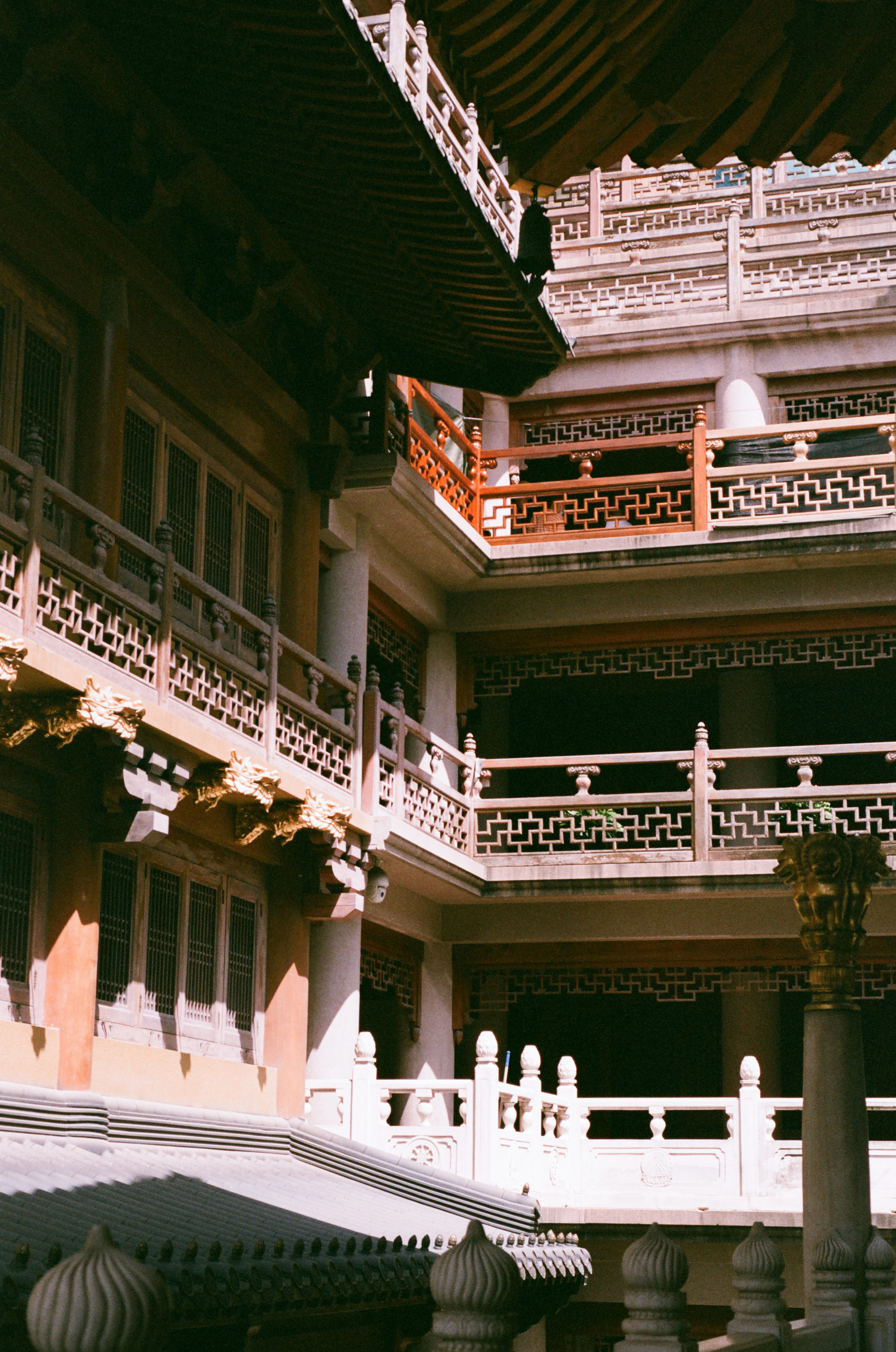 Photo of Traditional east asian temple courtyard with intricate architecture and balconies. by Xander Gonera