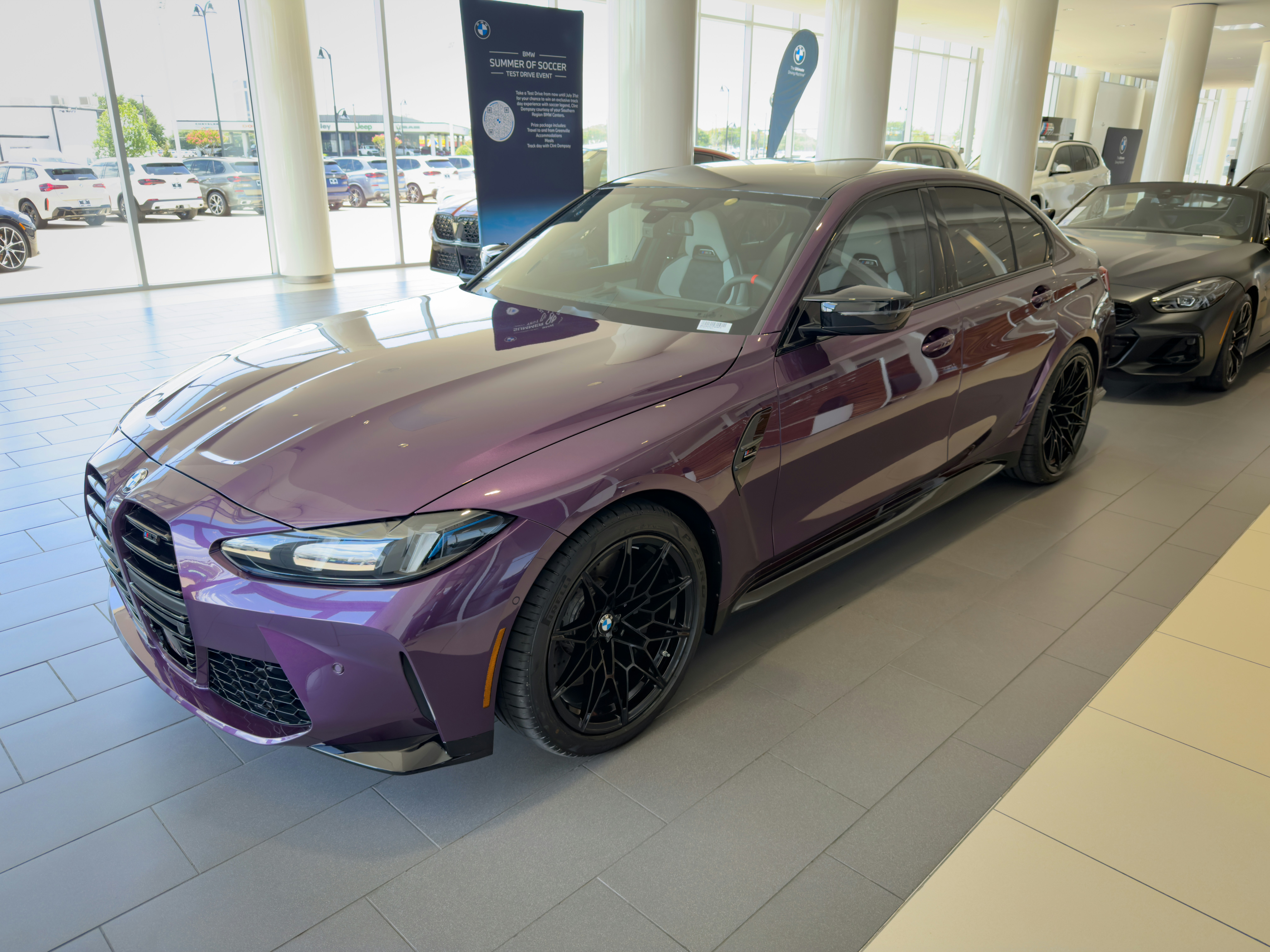 car dealership lot new cars - Purple BMW sports car displayed in a bright car dealership.