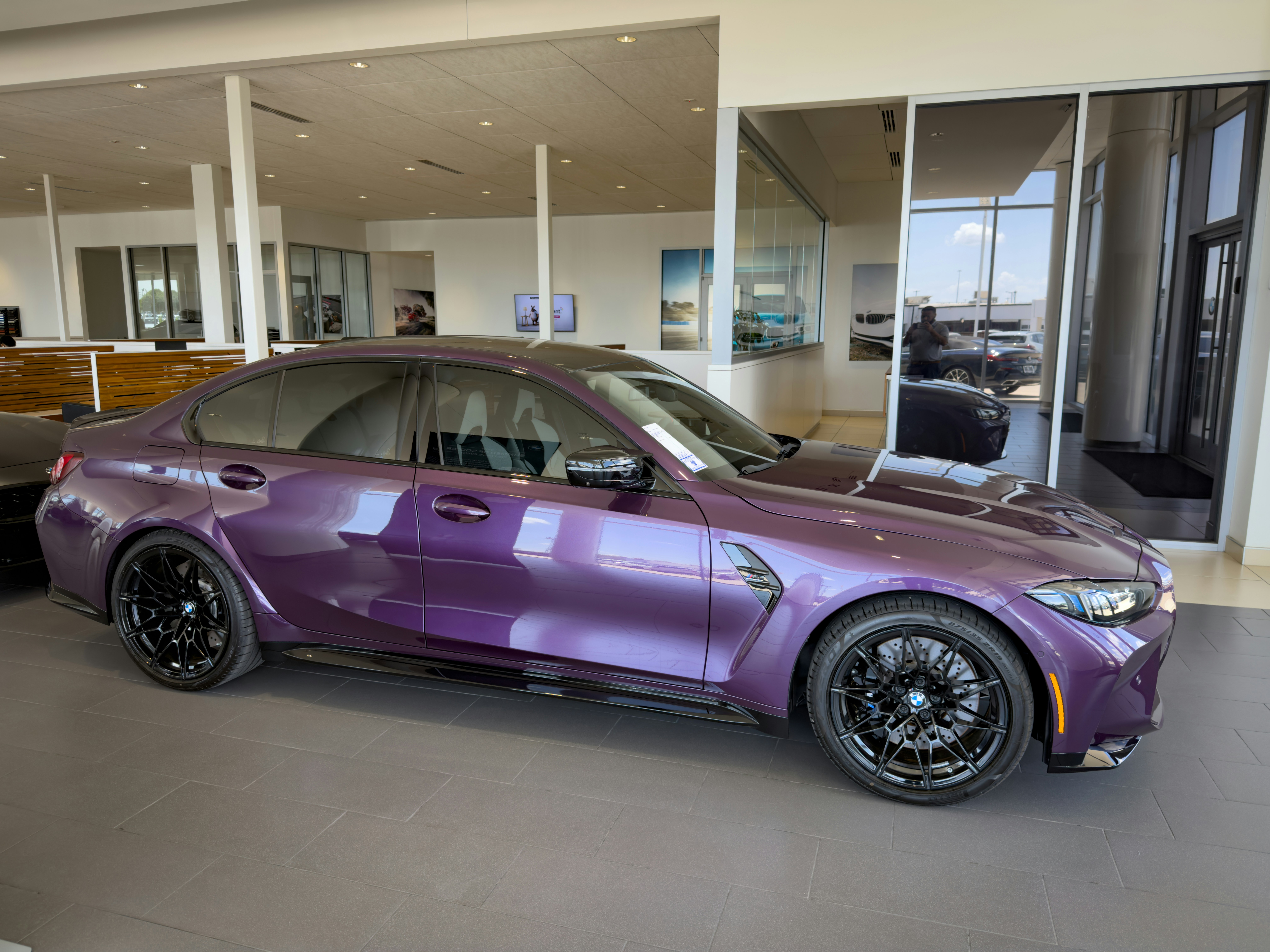 A purple sports car displayed in a modern car showroom