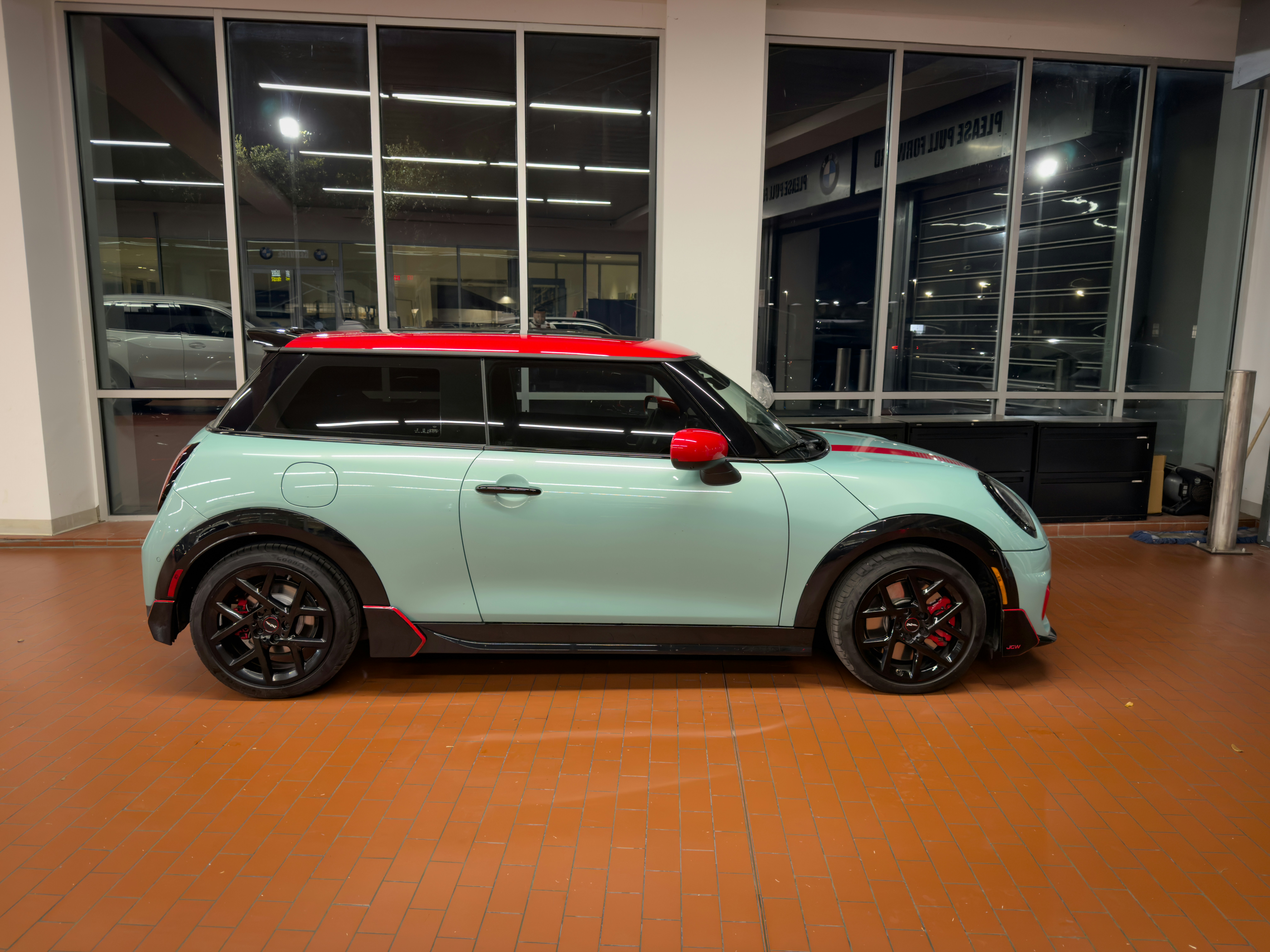 Mintgrüner Mini-Cooper mit rotem Dach im Showroom.