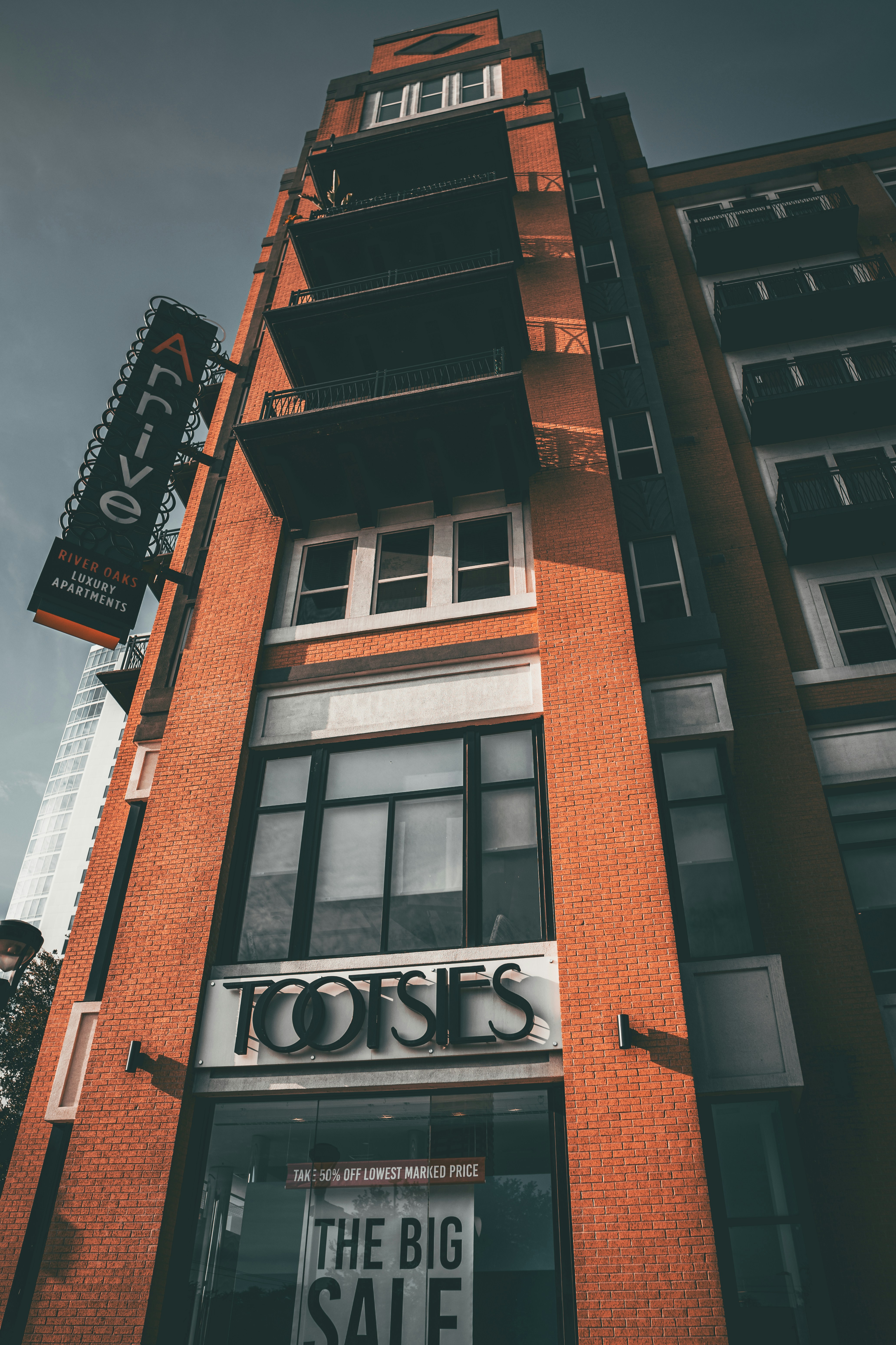 Un alto edificio in mattoni con cartelli "tootsies" e "arrive".