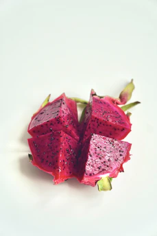 Vibrant red dragon fruit pieces on a clean white background.