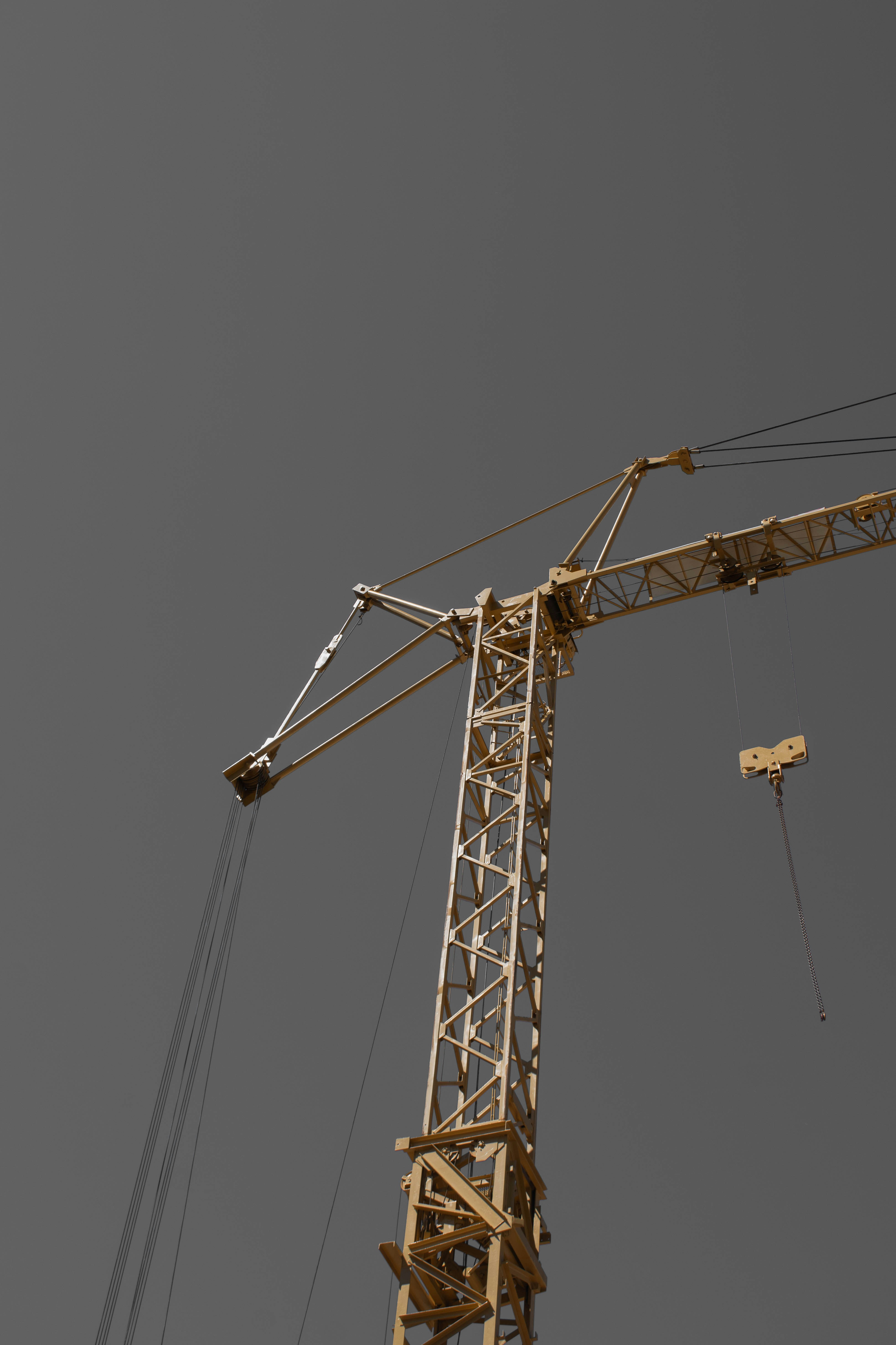 A large yellow construction crane against a grey sky