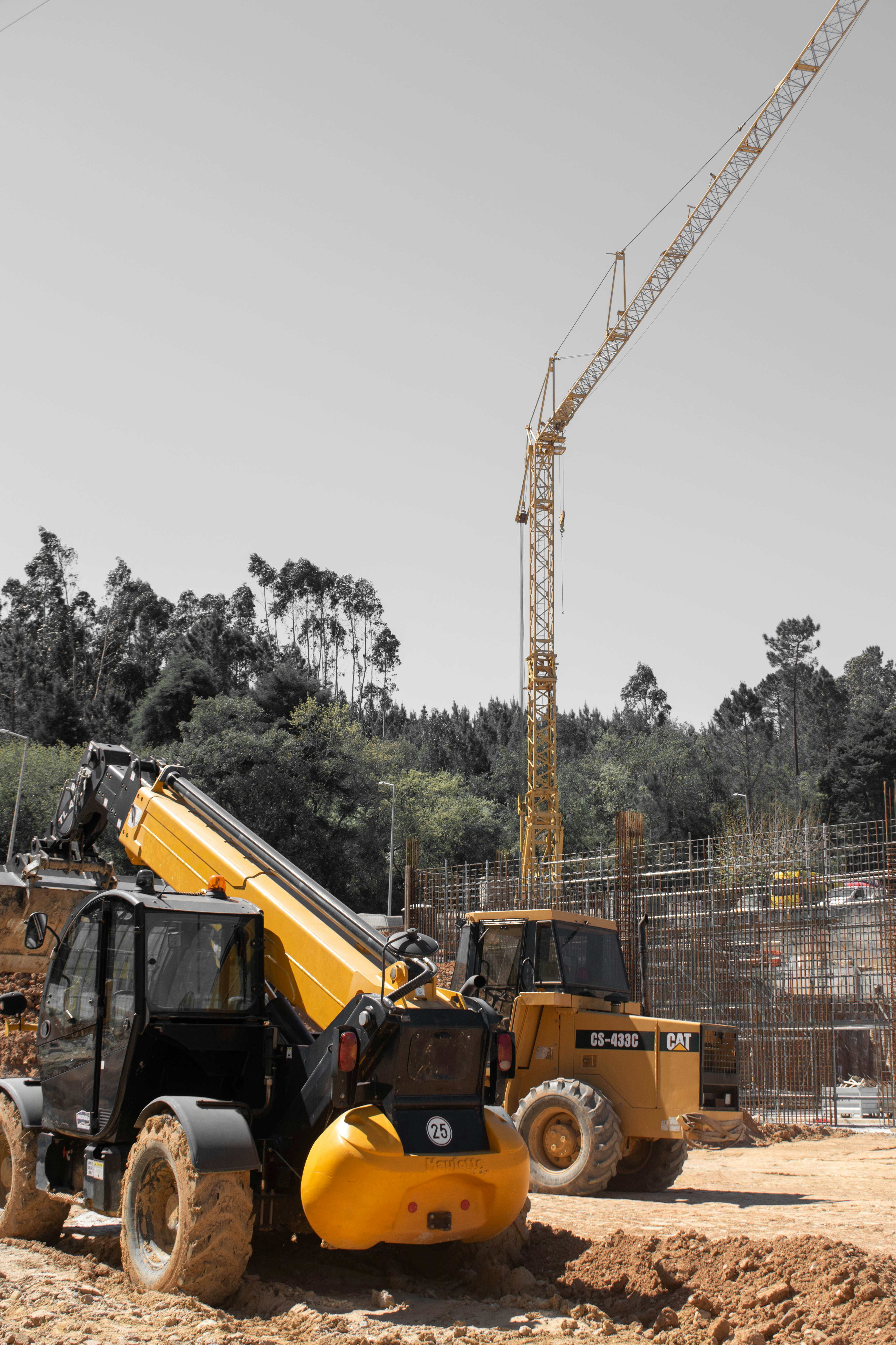 Yellow construction crane and heavy machinery at a building site