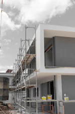 Modern building under construction with scaffolding and paint cans