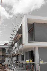 Modern building under construction with scaffolding and paint cans