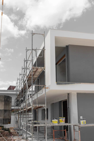 Modern building under construction with scaffolding and paint cans