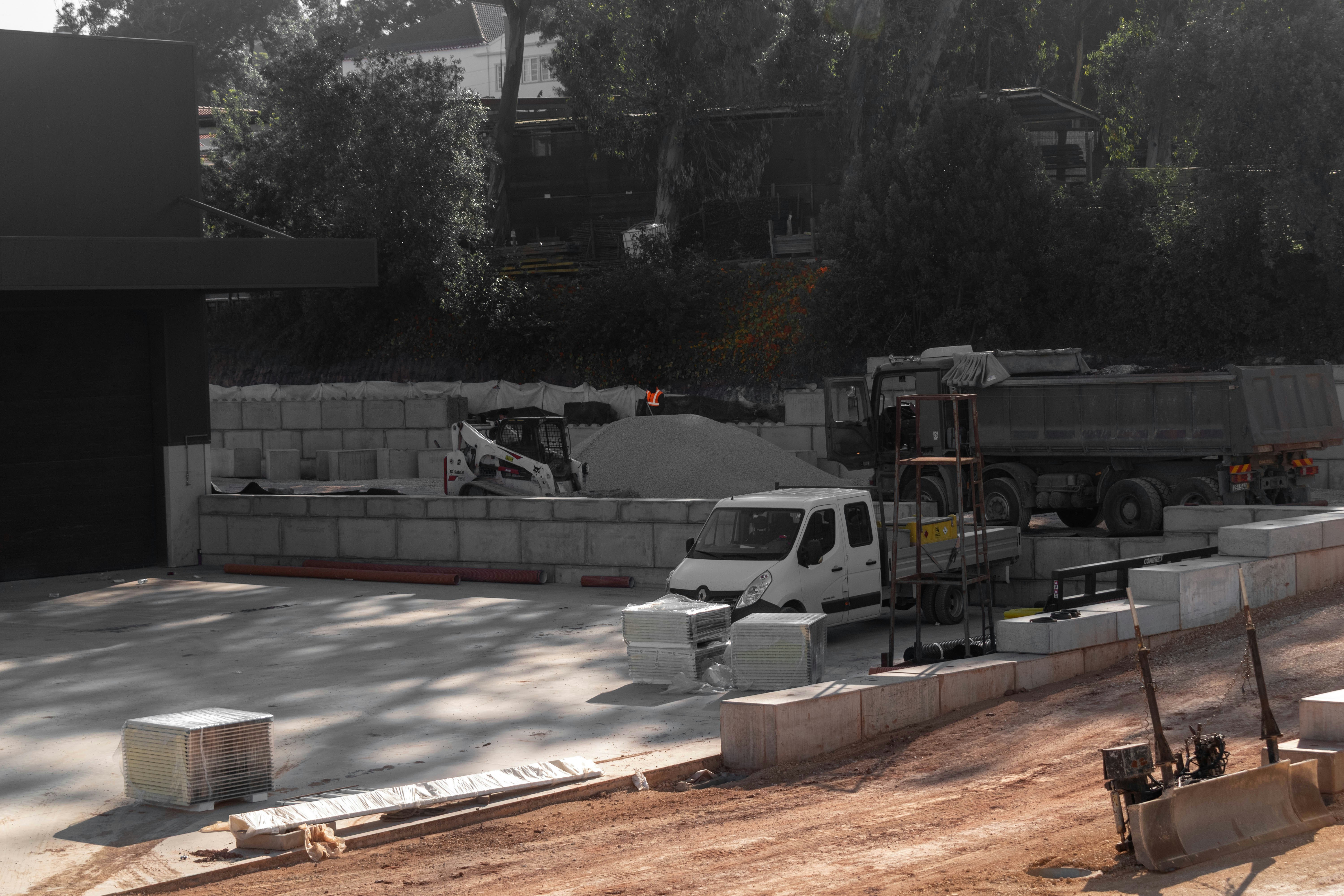Construction yard with trucks, concrete blocks, and aggregate piles