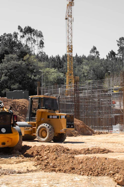 Yellow construction vehicle and crane at a building site.