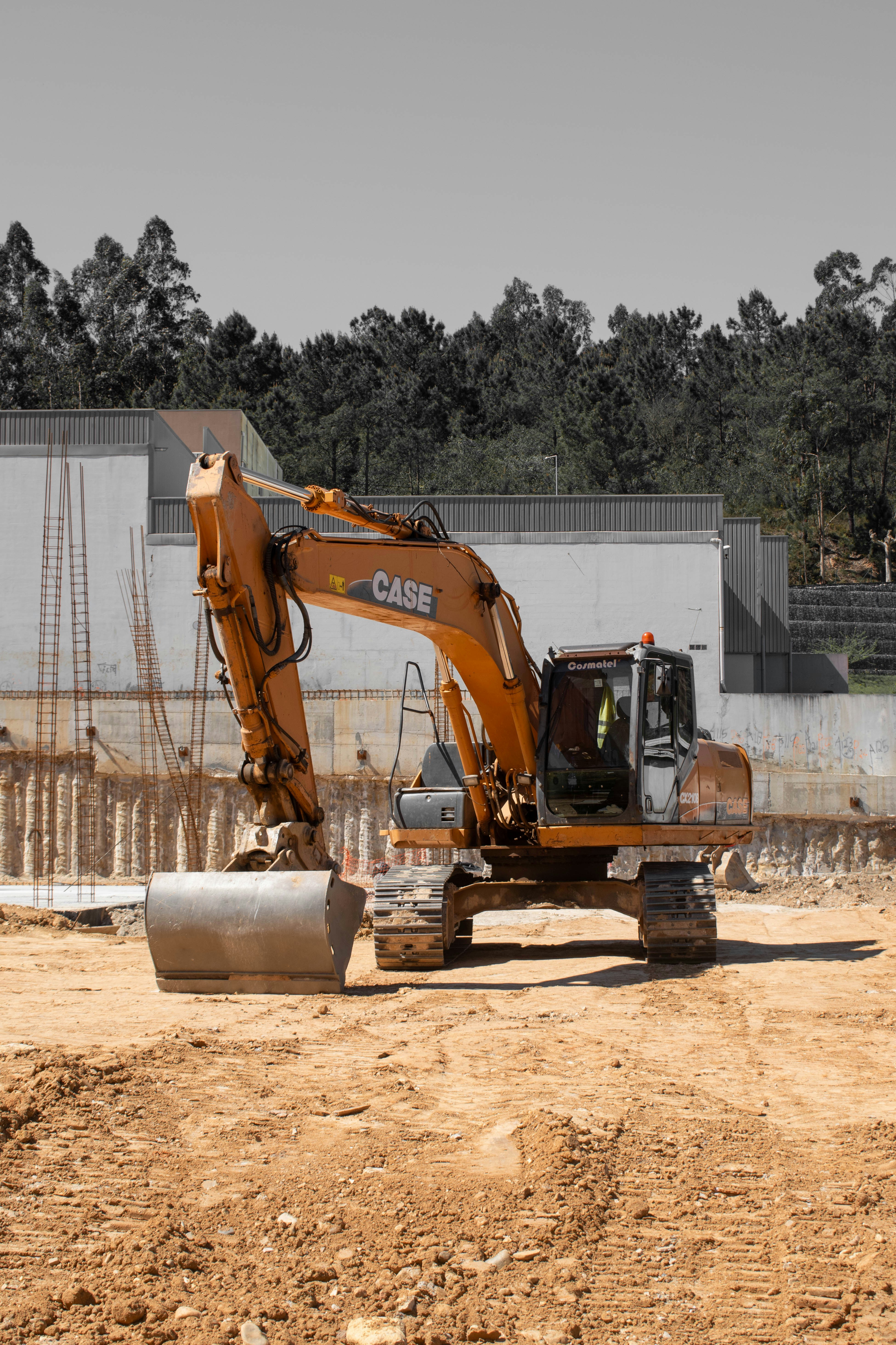 An orange case excavator stands on a dirt construction site