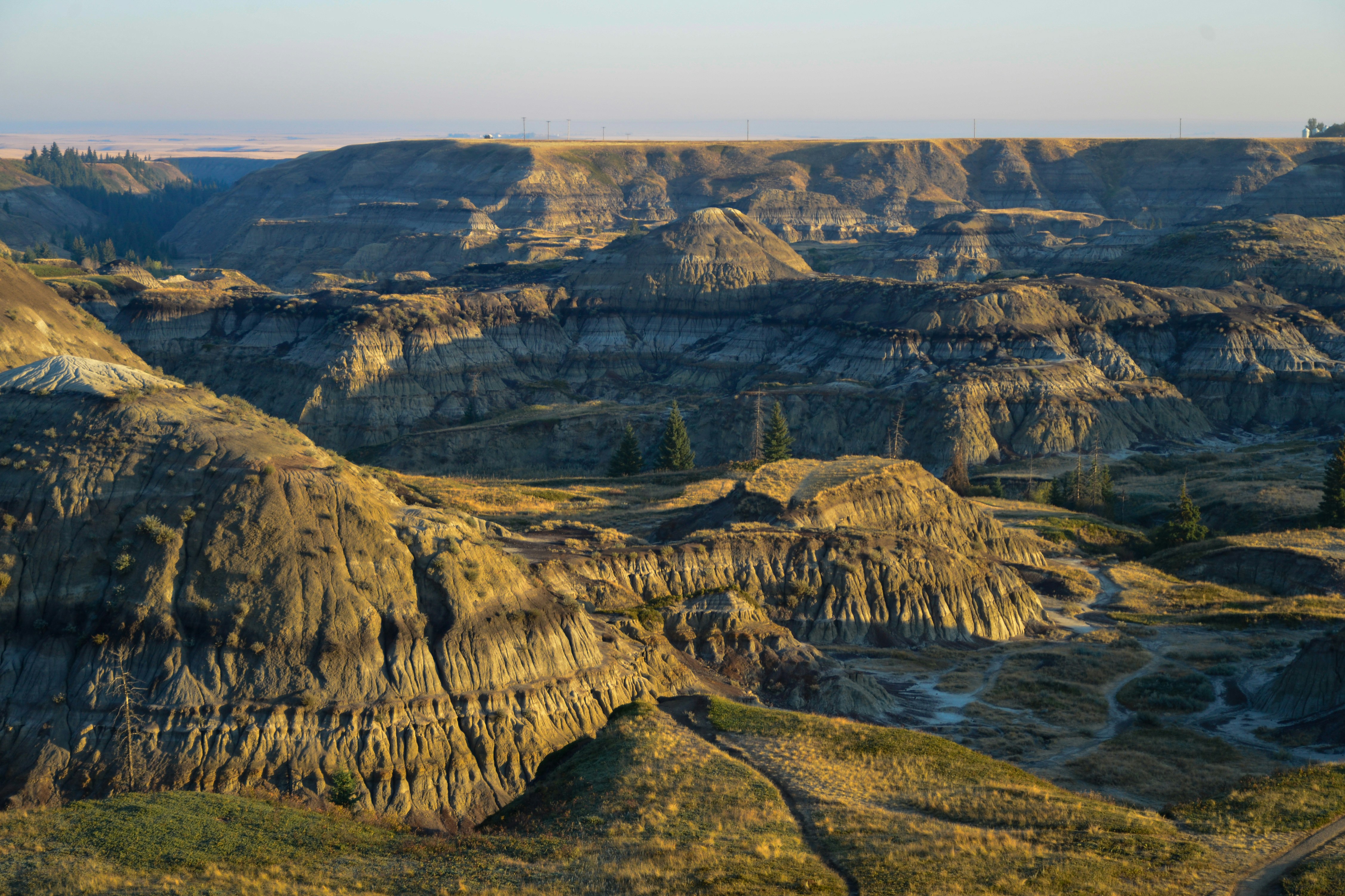 Paesaggio drammatico delle badlands con formazioni rocciose erose al tramonto.
