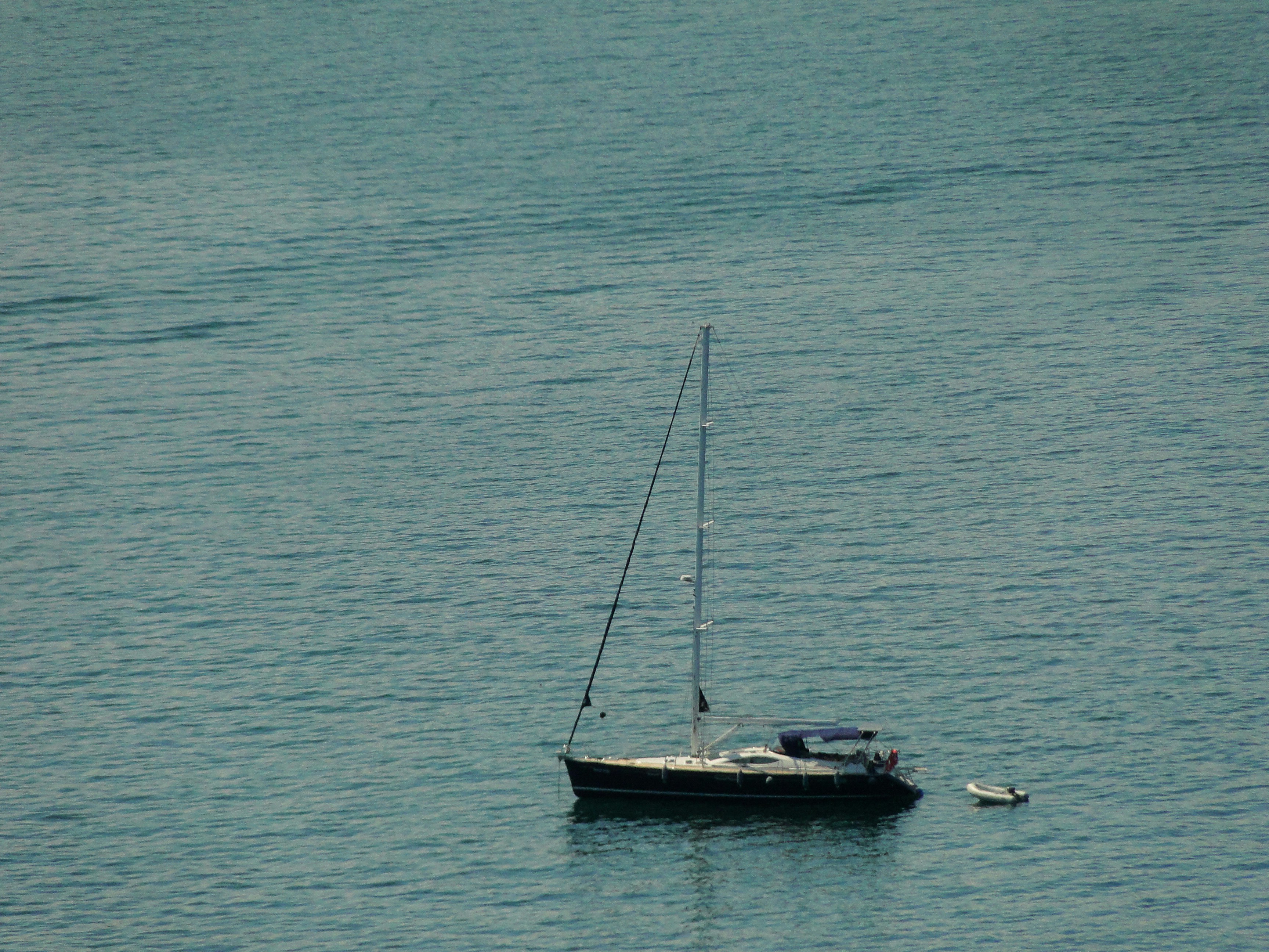 Ocean A Sailboat And Small Dinghy Anchored In Calm Blue Water. Full HD Wallpaper #3586