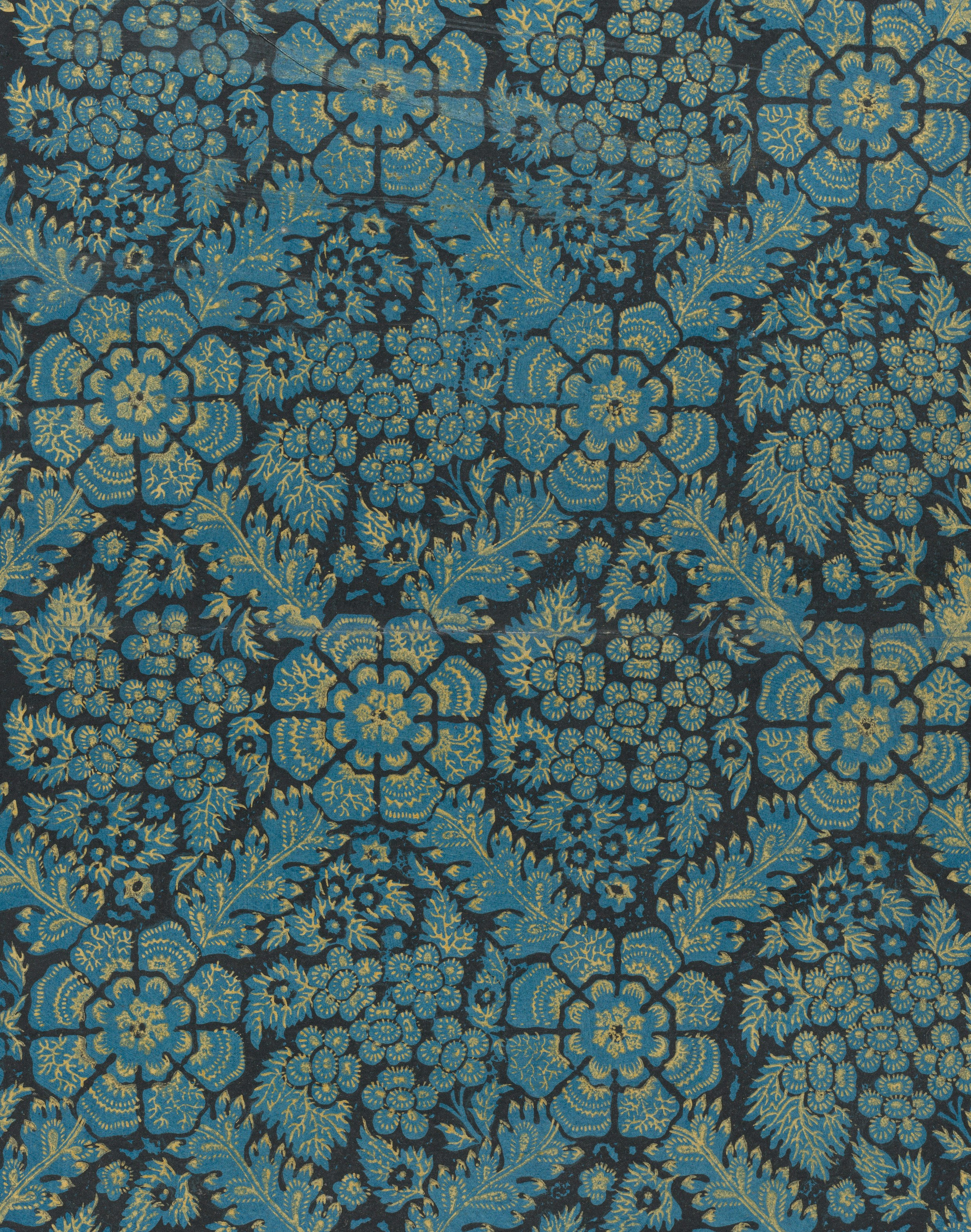 Intricate blue and yellow floral pattern on dark fabric