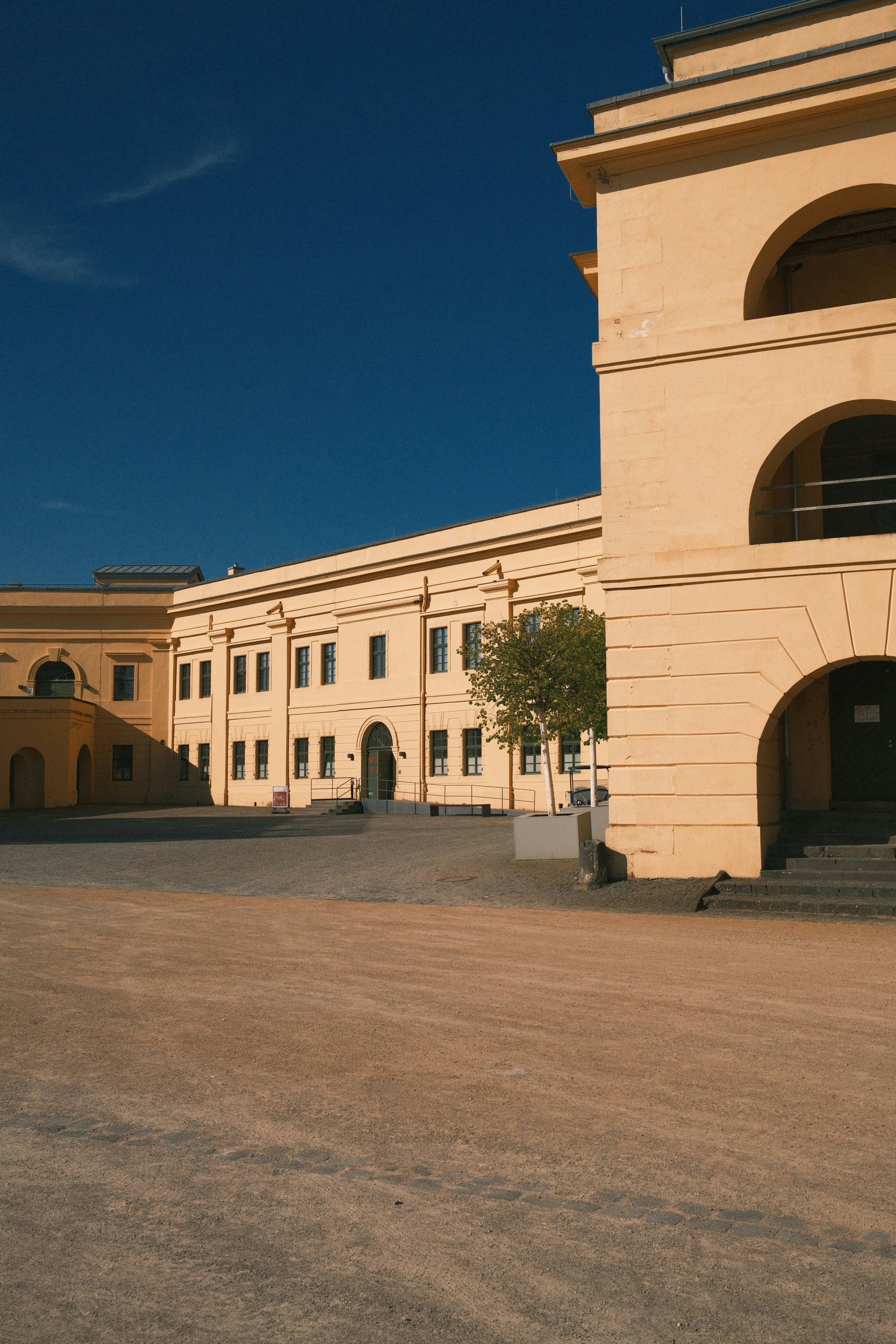 Yellow building and courtyard under a clear blue sky