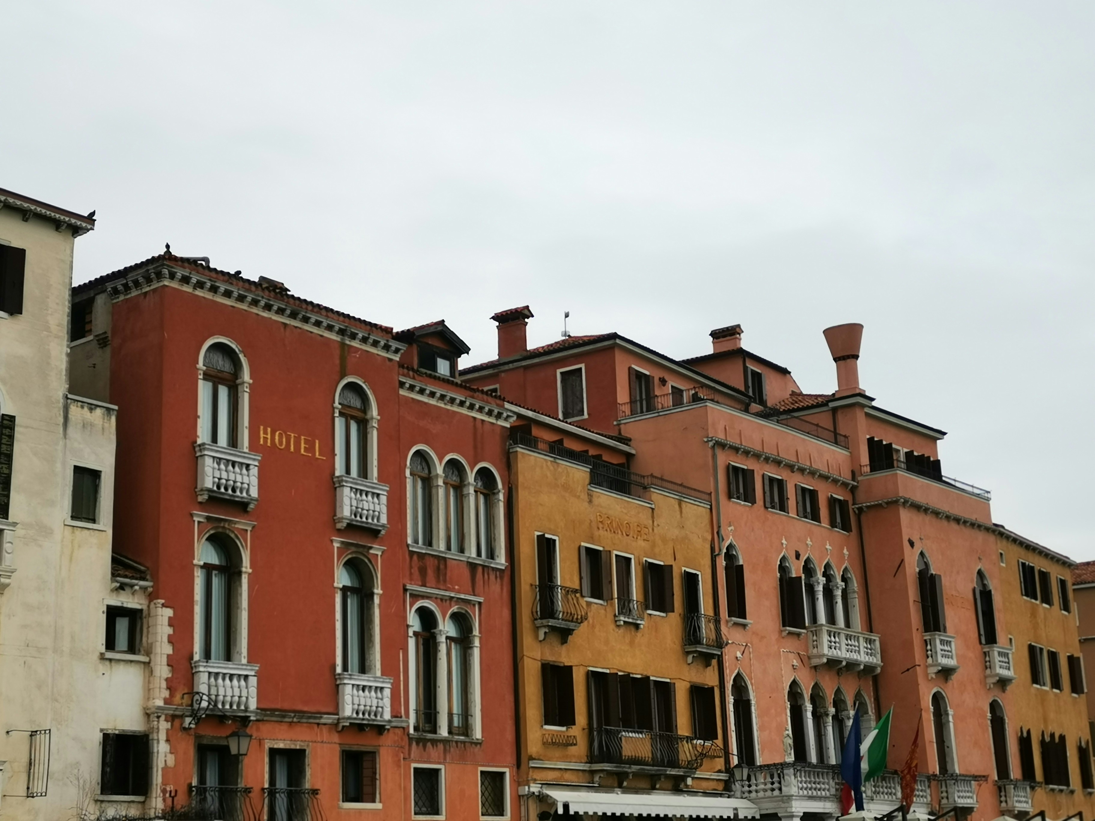 Colorful historic buildings with balconies under a cloudy sky.