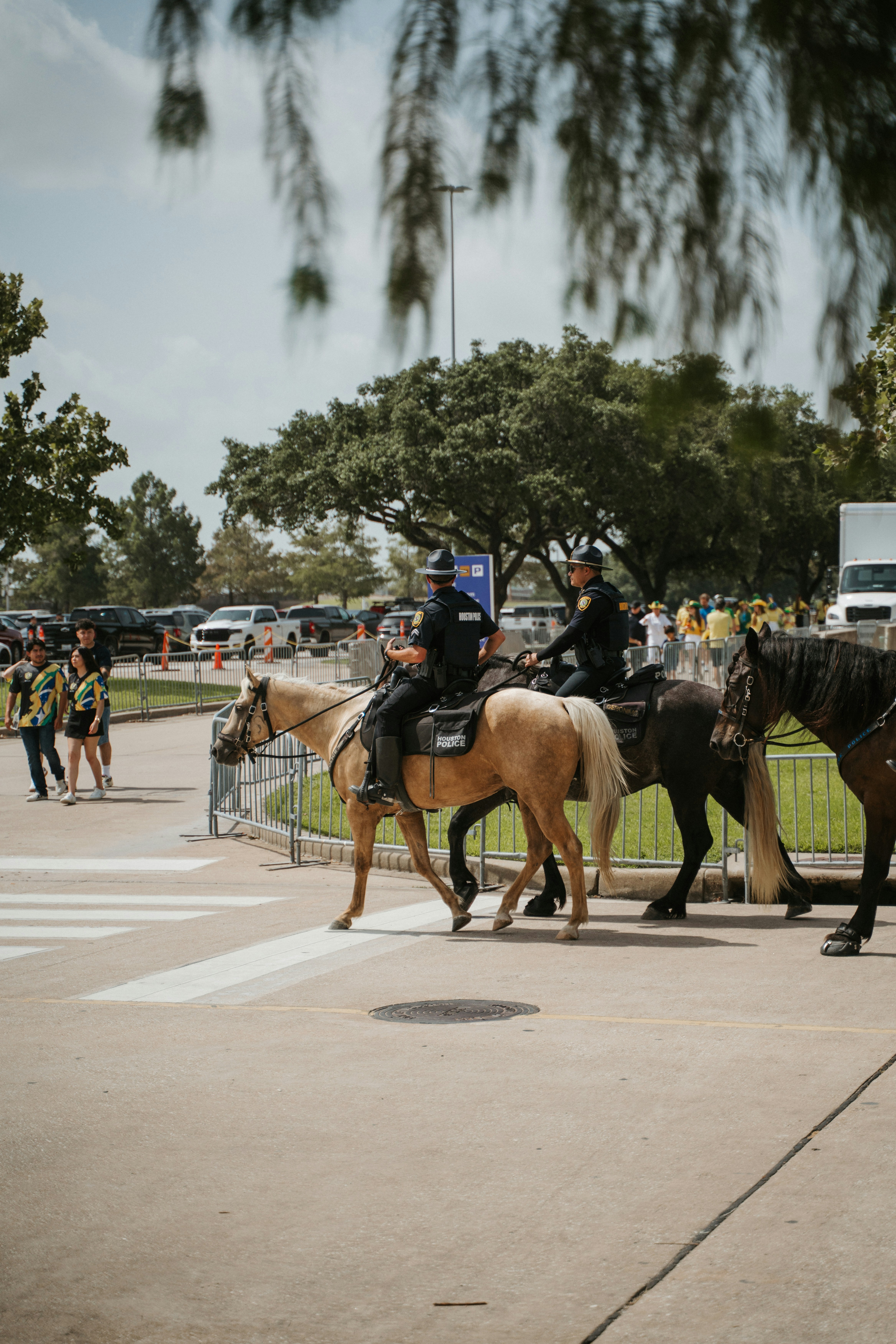 Policiais montados patrulham a cavalo ao ar livre.