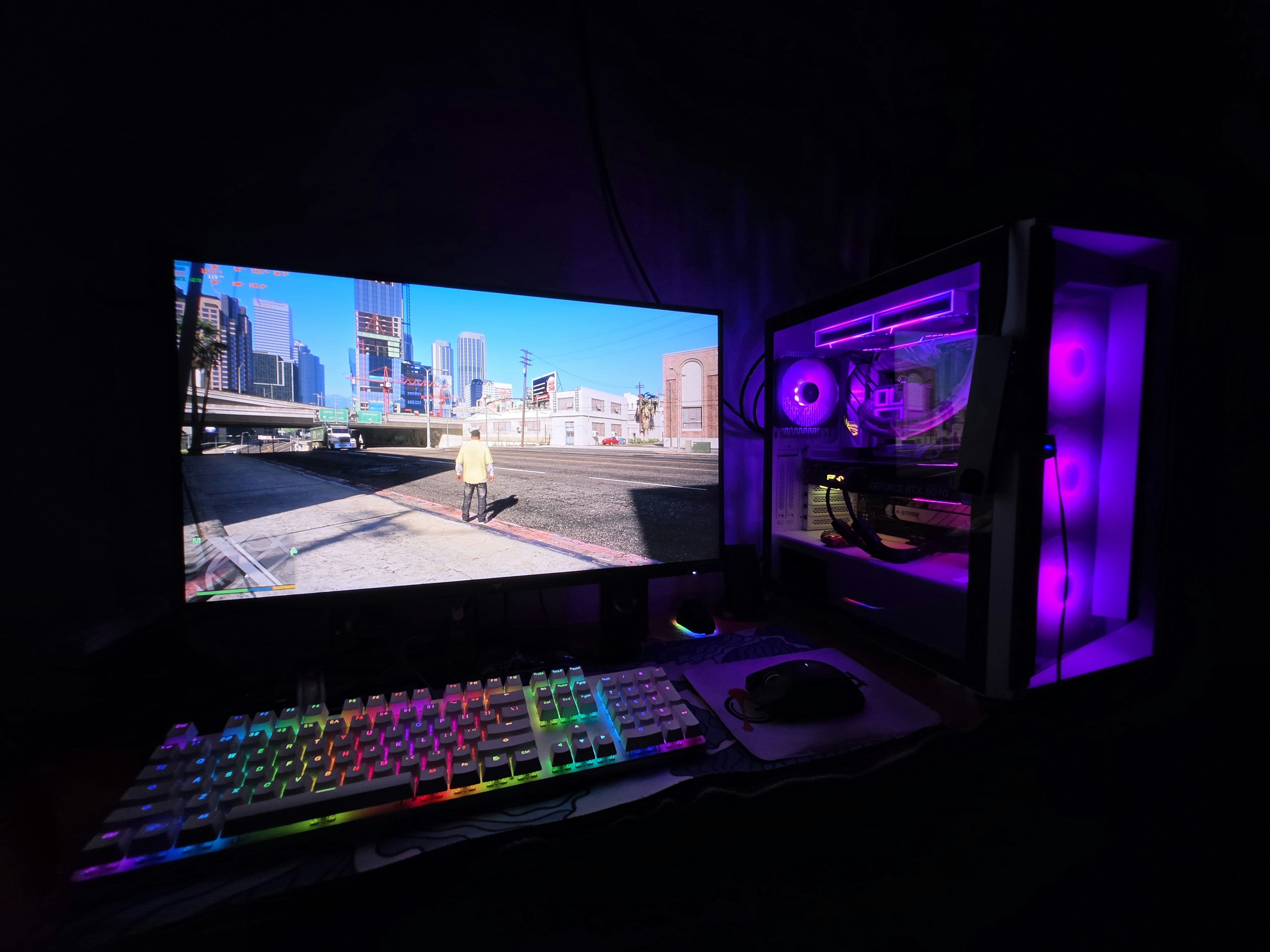 Gaming PC setup with monitor, game, and colorful rgb lighting.
