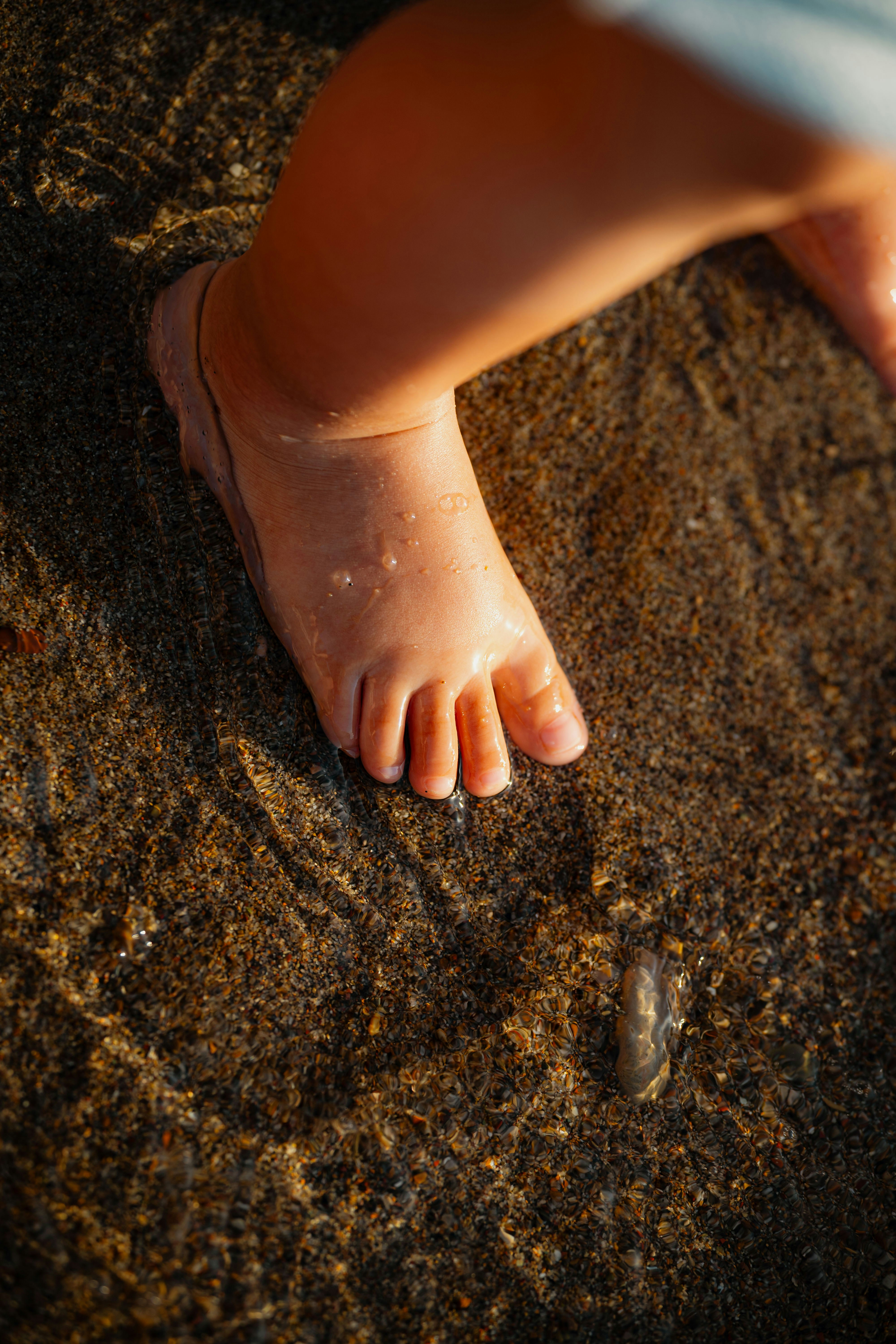 Photo of Baby's foot stepping into shallow water by Emanuel Haas
