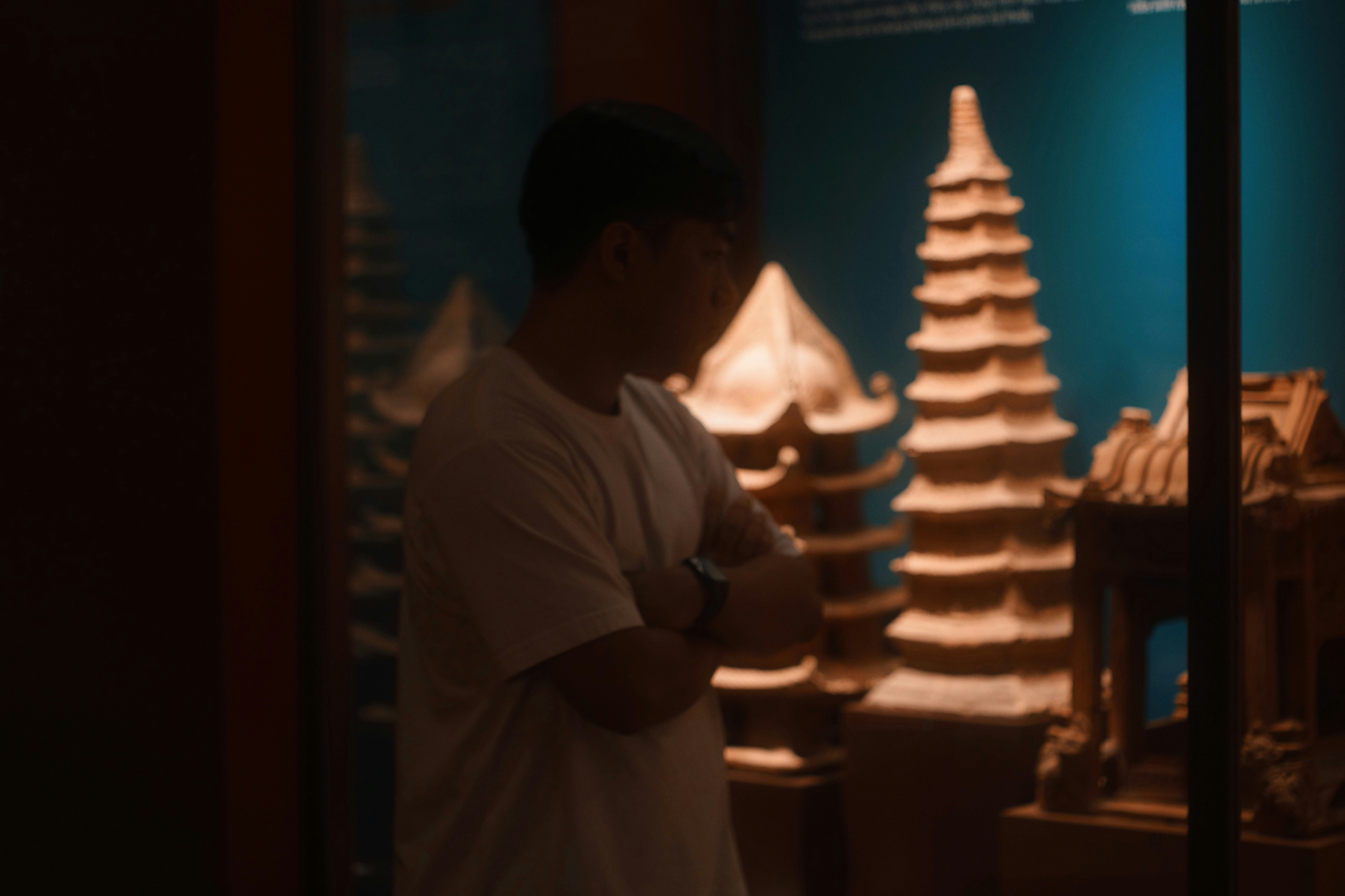 A person looking at ancient architectural models in a museum.
