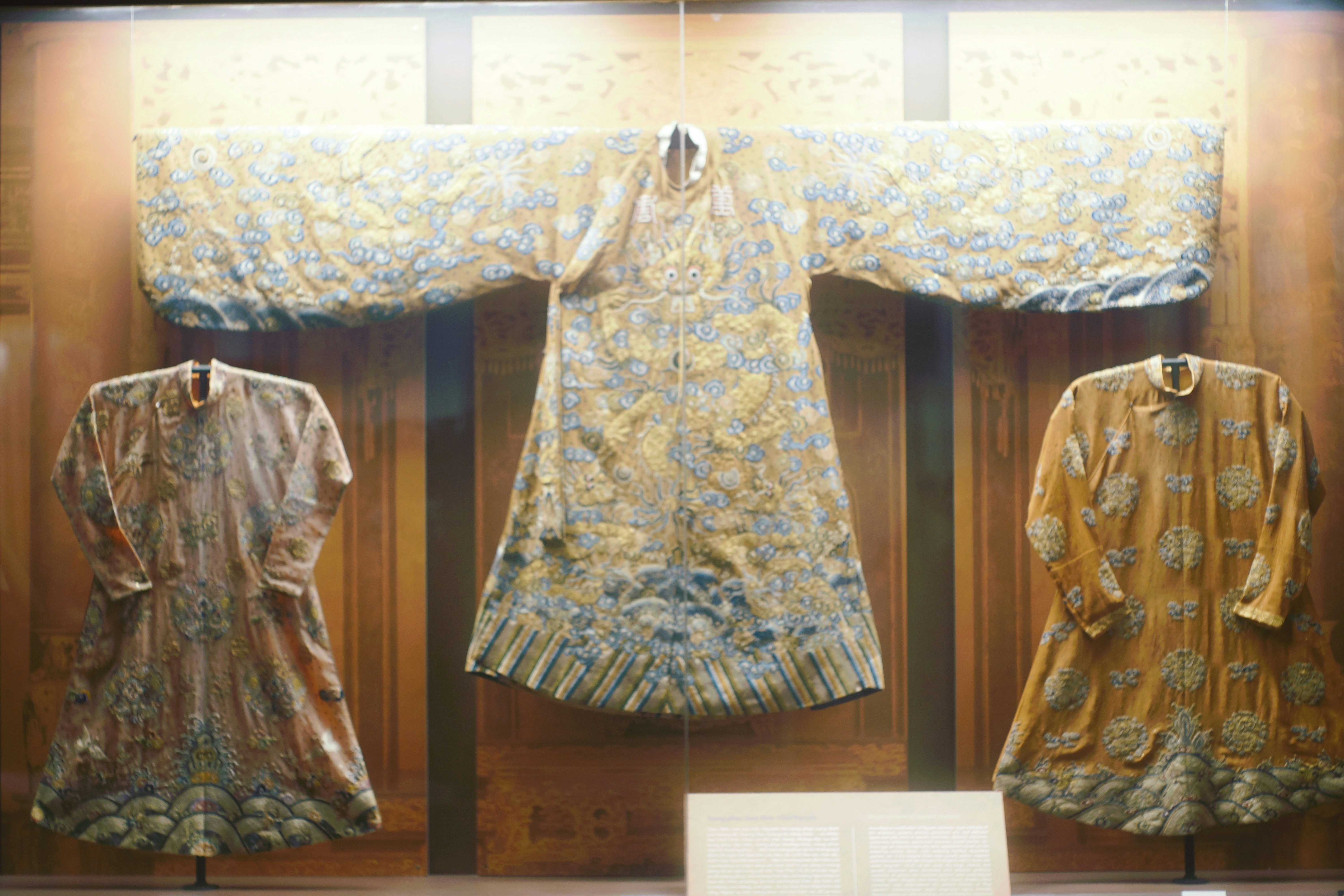 Ornate embroidered robes displayed in a museum exhibit.