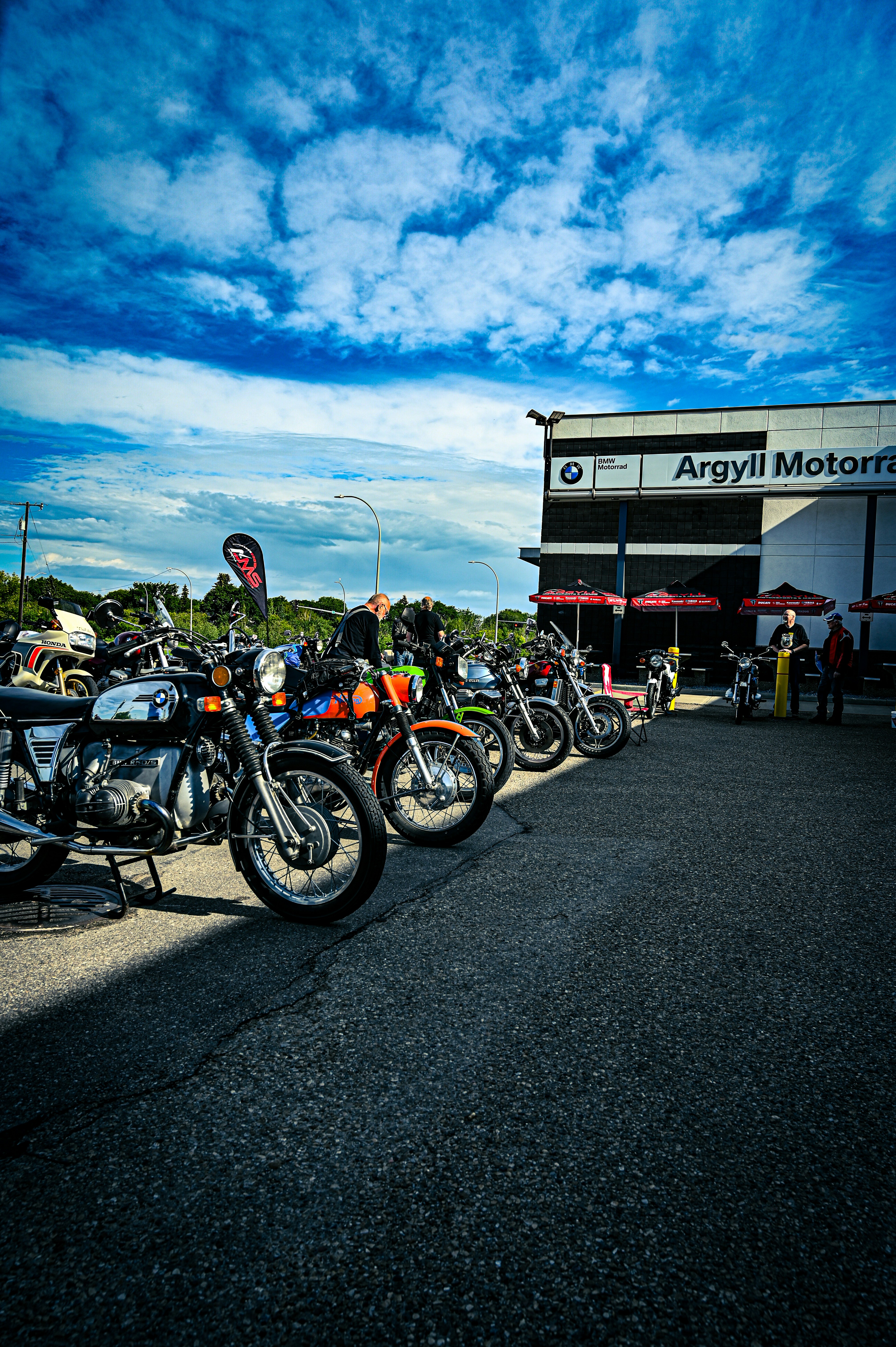 Classic motorcycles parked outside argyll motorfarms under a blue sky