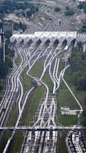Numerous train tracks lead into a large, modern station building
