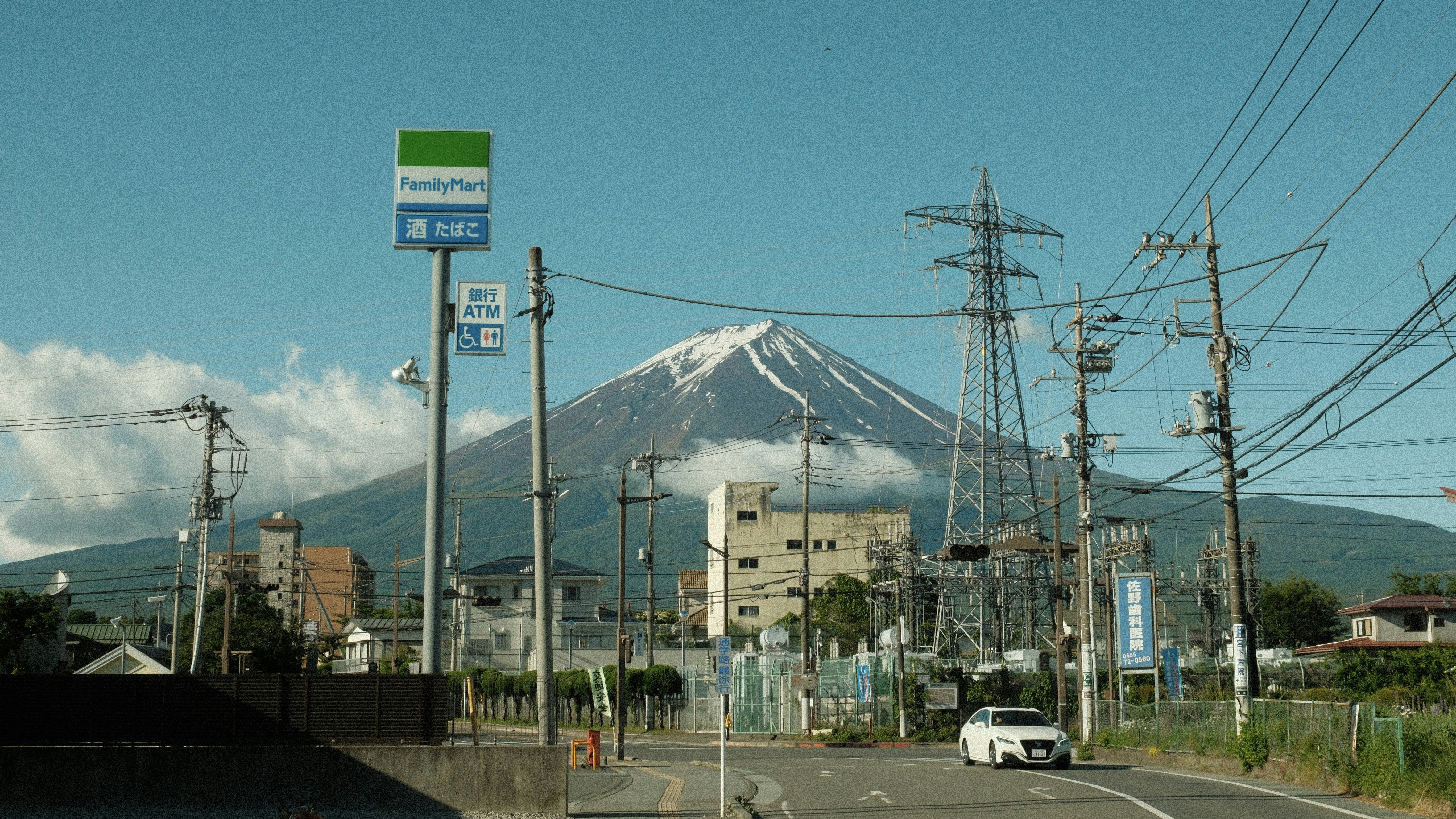 Majestic mount fuji looms over a town with power lines