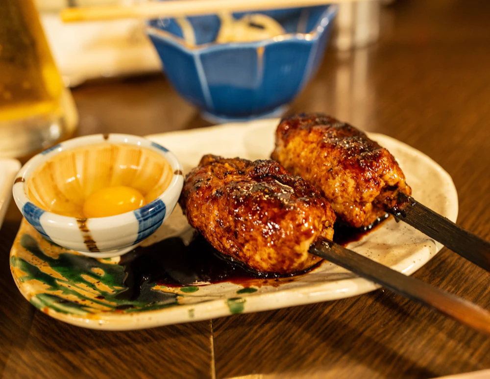 Two tsukune skewers and an egg yolk