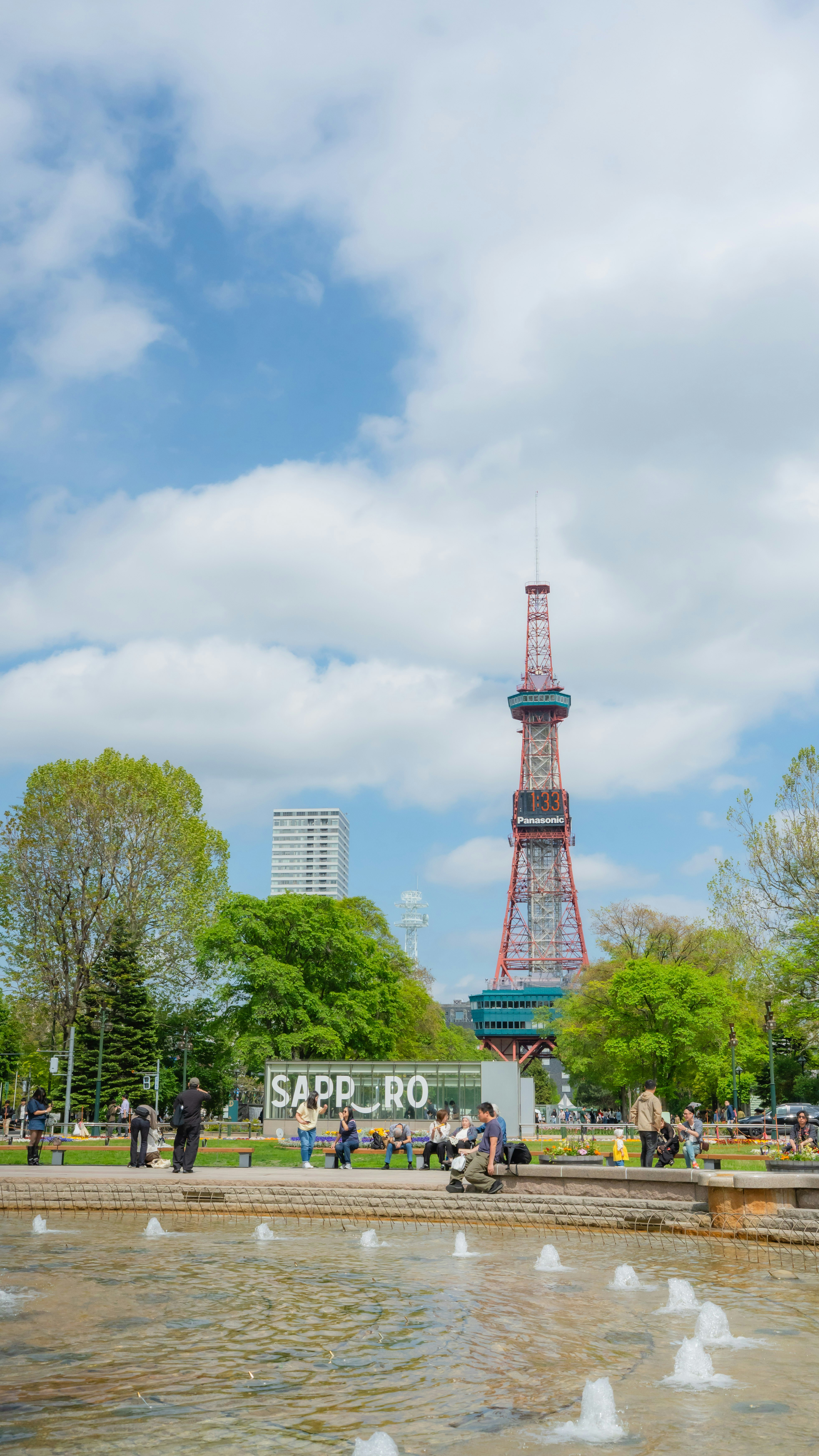 Tour de télévision de Sapporo, parc, fontaine et des gens sous un ciel bleu