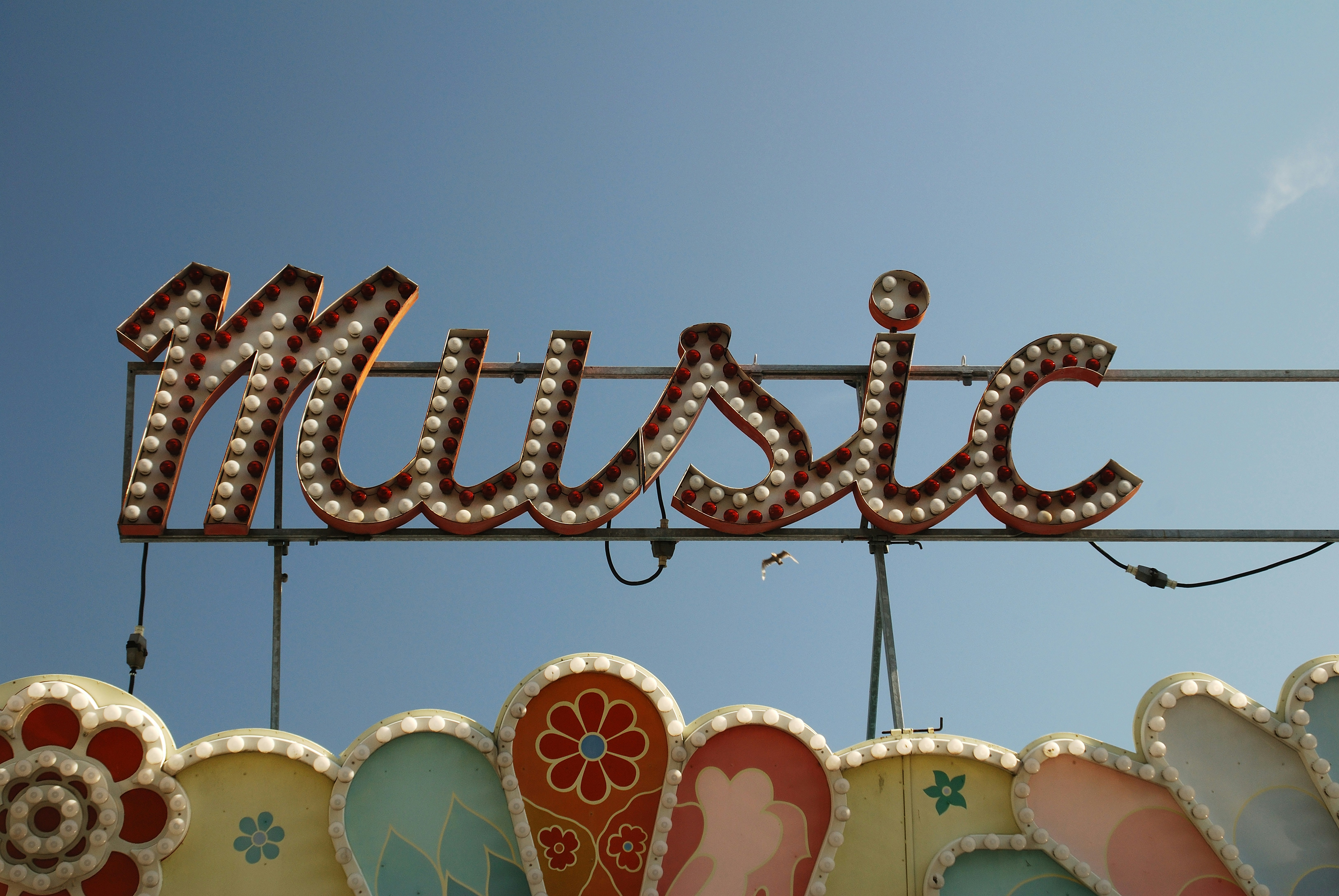 Tanda "musik" vintage dengan lampu di langit biru.