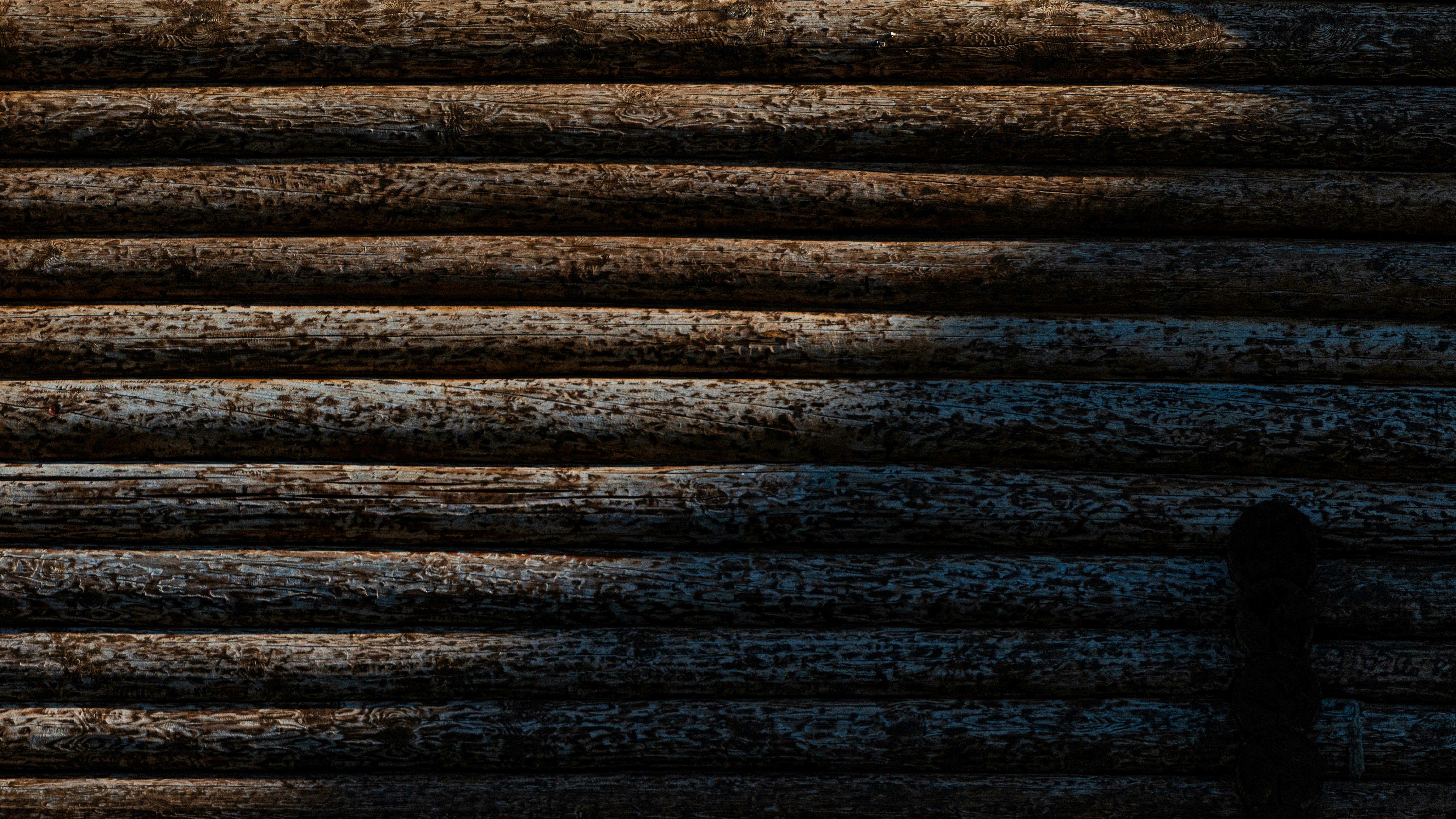 Muro rustico di legno con luce e ombra a contrasto.