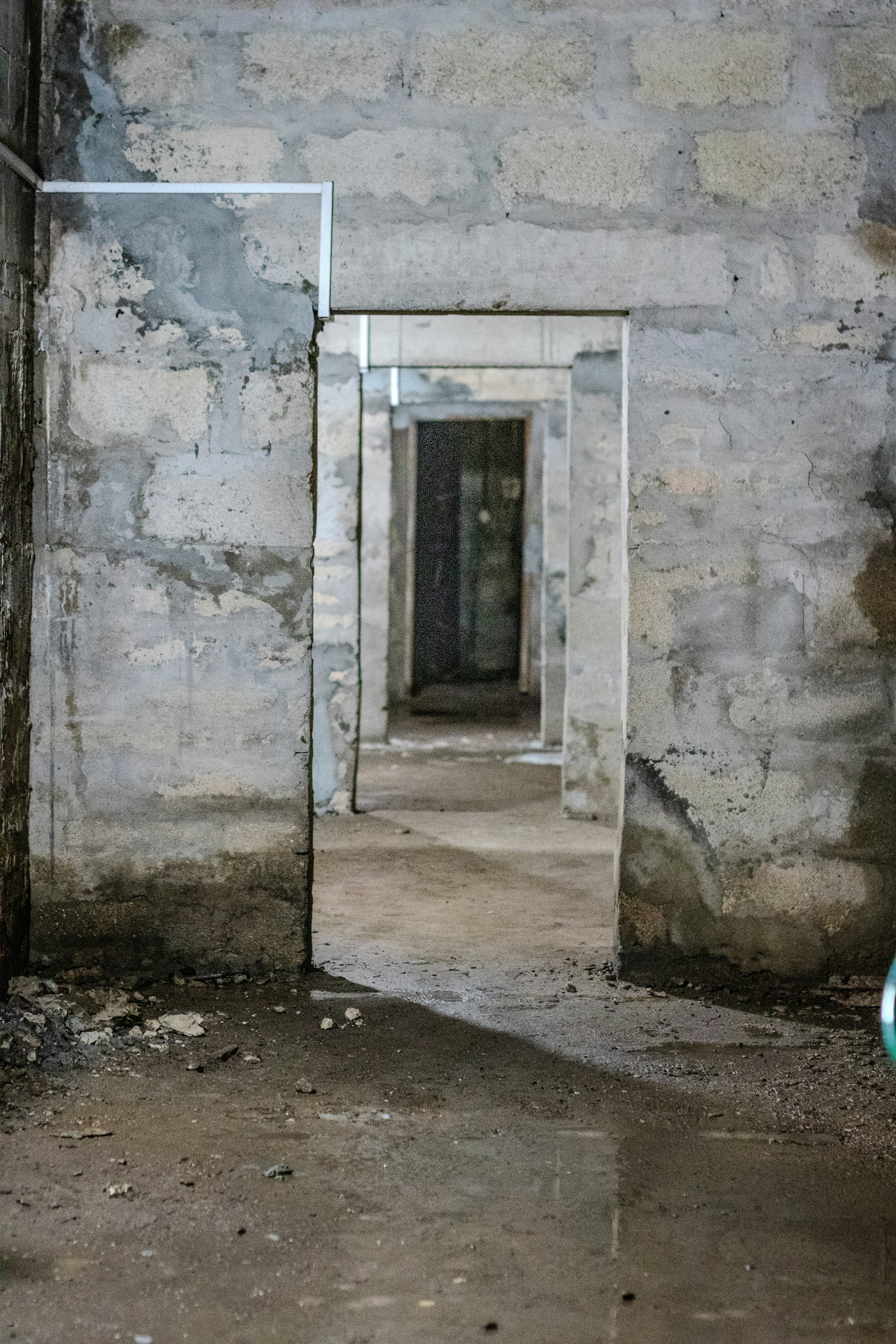Zurückziehende Türrahmen in einem dunklen, unfertigen Betongebäude