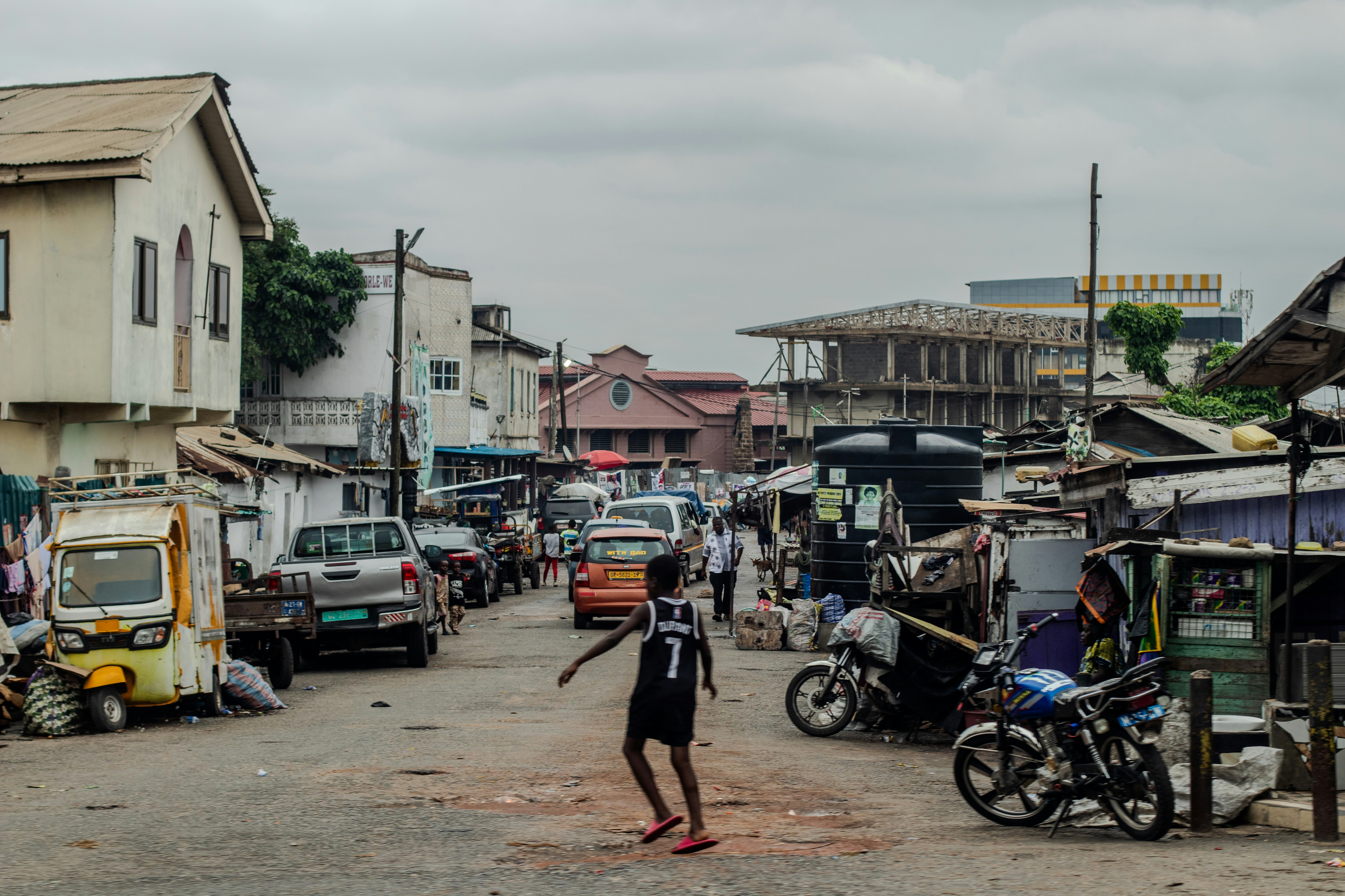 Child walks on a busy urban street with vehicles.