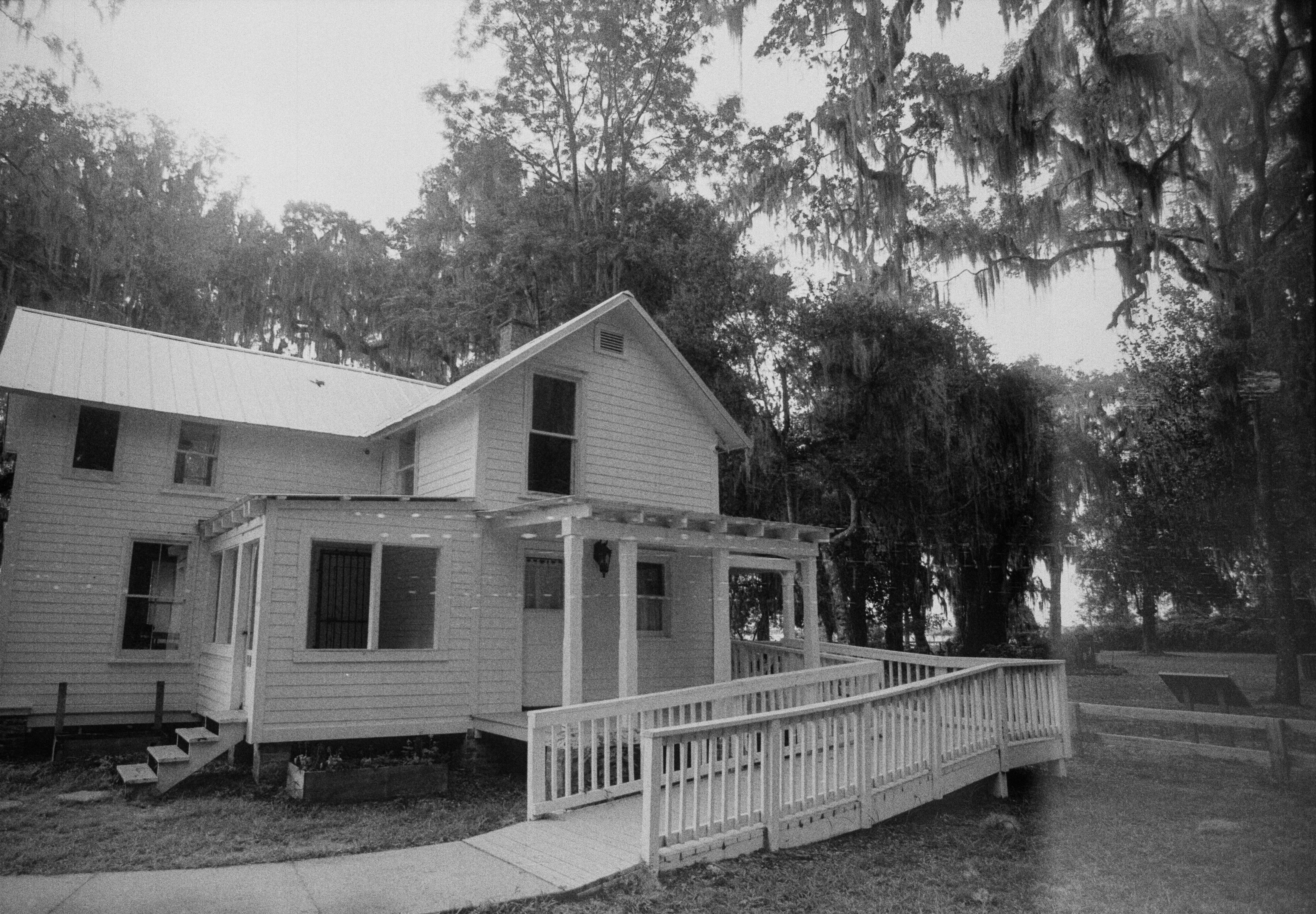 White two-story home with an accessibility ramp at the front entrance