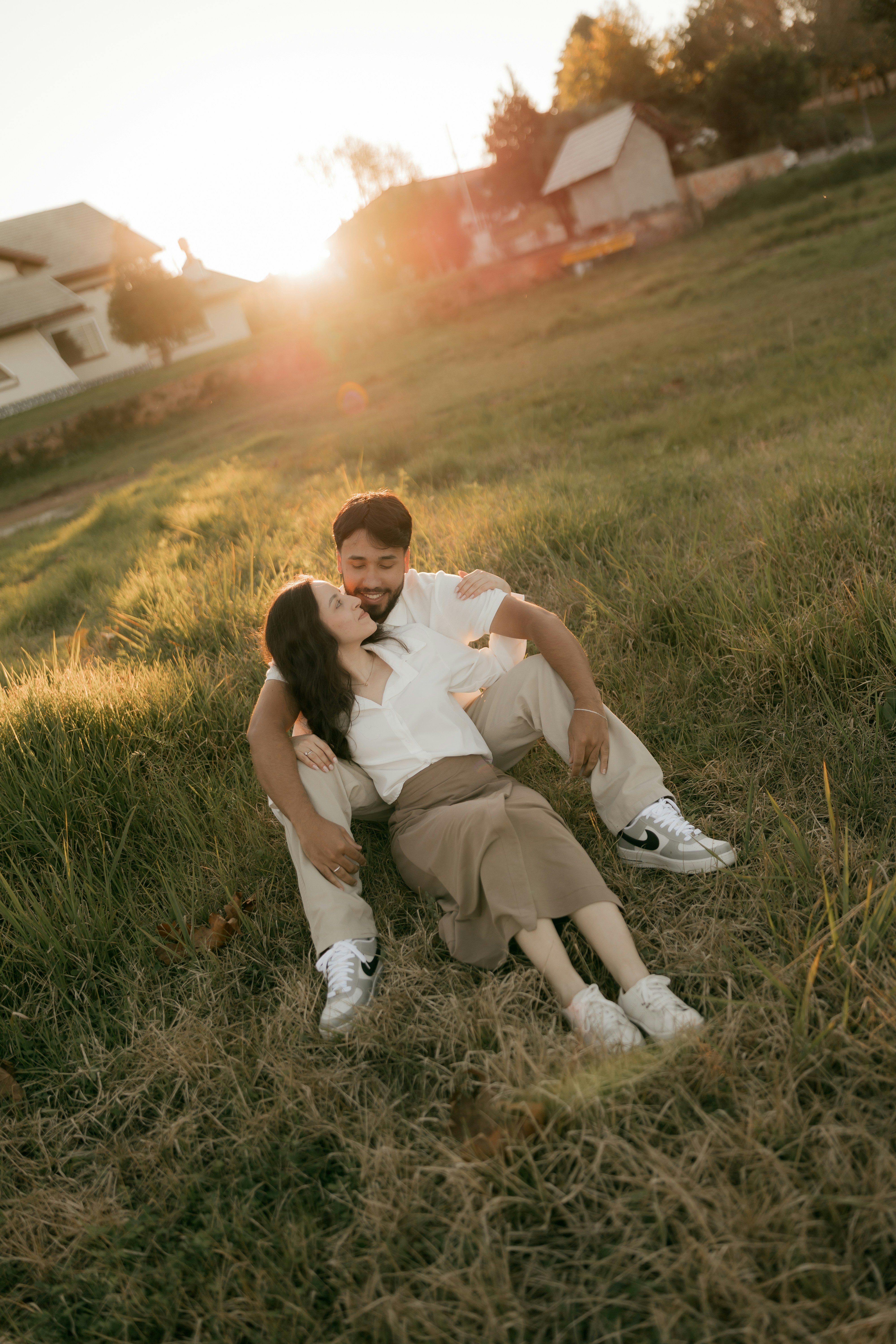 Romantic couple enjoying sunset on a grassy hillside