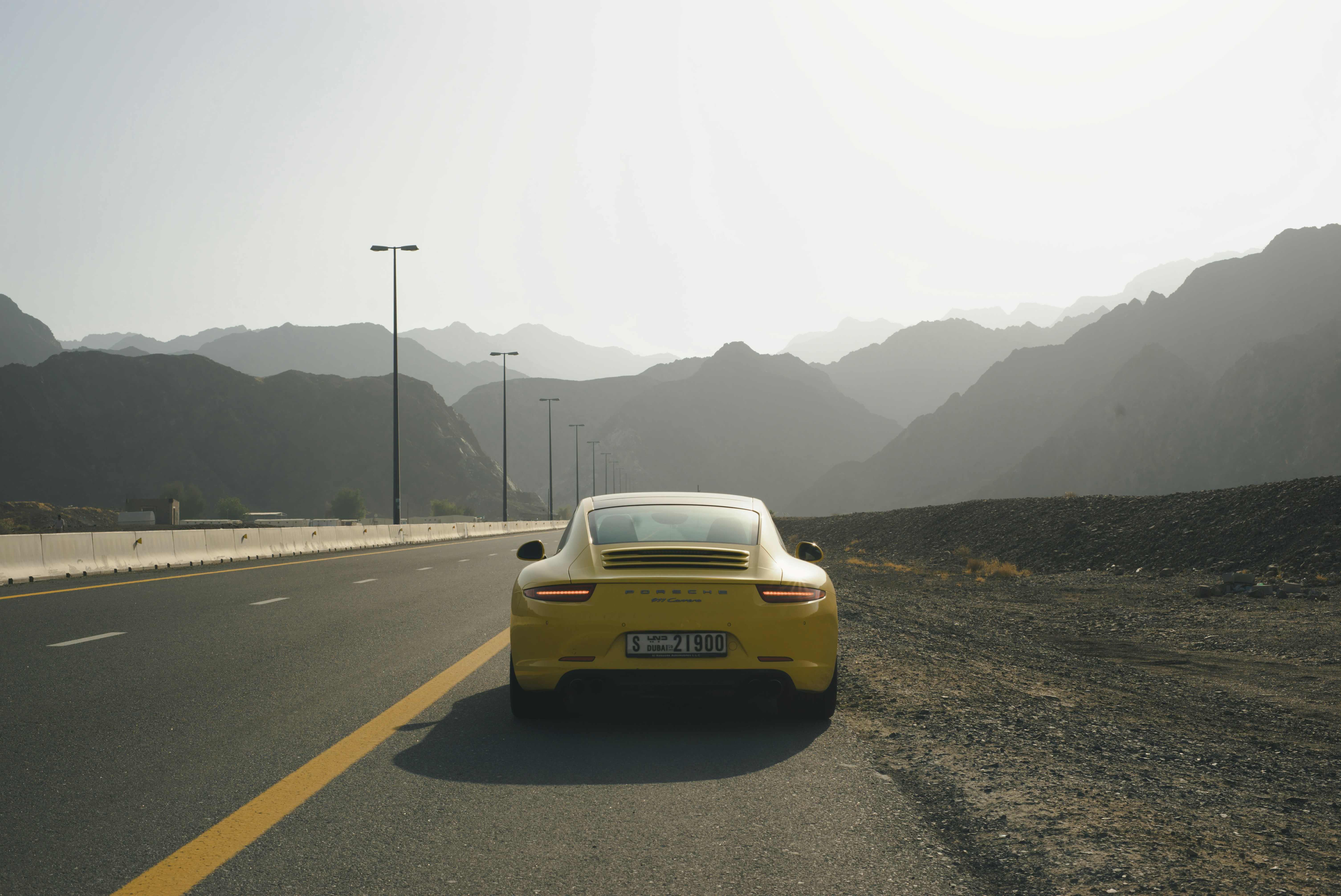 Cars Yellow Sports Car On A Highway With Mountains In Background. 4K Wallpaper #3287