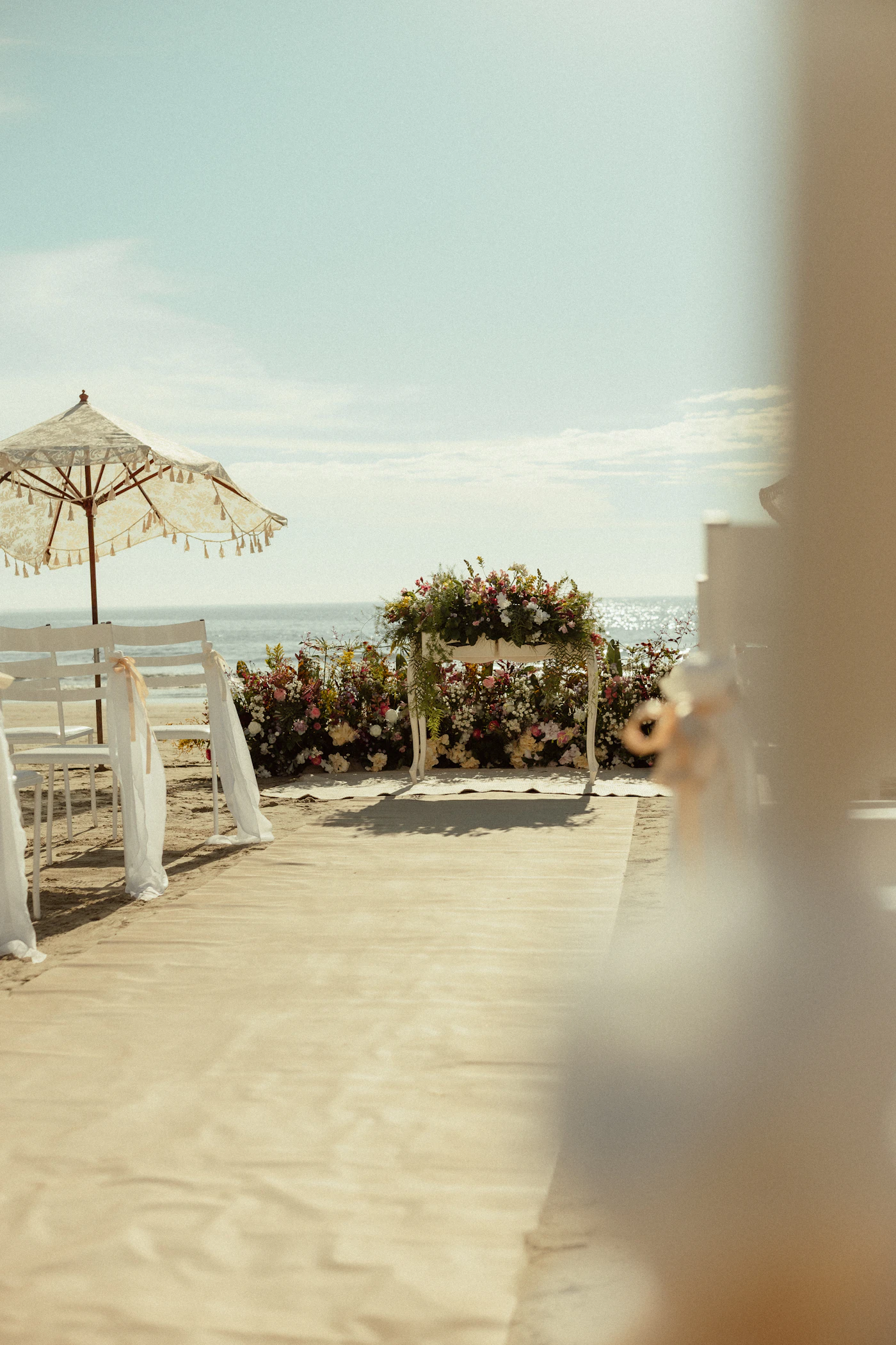 DIY chair decorations for outdoor ceremonies — A close-up of a simple wedding chair sash with trailing ribbons.